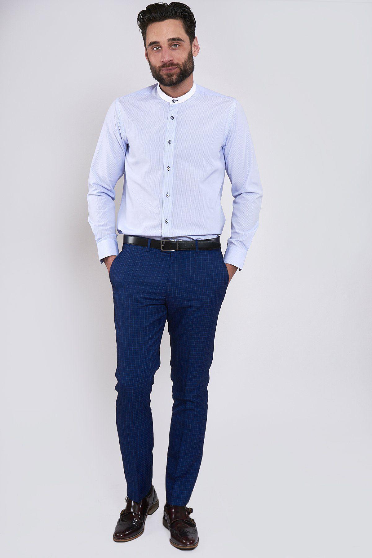 A man in a Marc Darcy COOPER Grandad Collar Sky Blue Stripe Shirt, dark blue checkered pants, black belt, and brown double monk strap shoes.