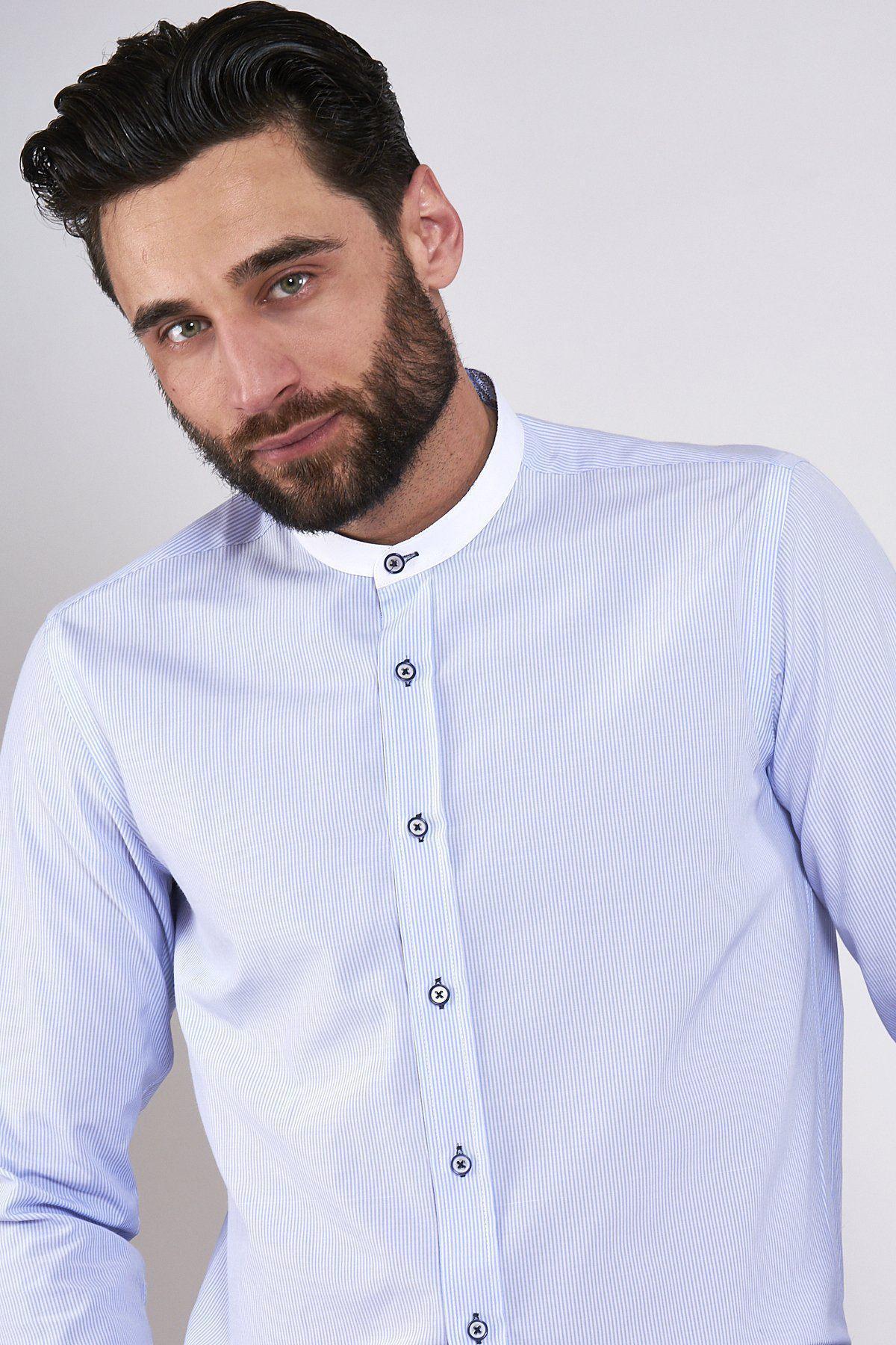A man with dark hair and a beard wears the Marc Darcy COOPER Grandad Collar Sky Blue Stripe Shirt, featuring a subtle pinstripe. He stands against a plain light background, looking slightly to the side.