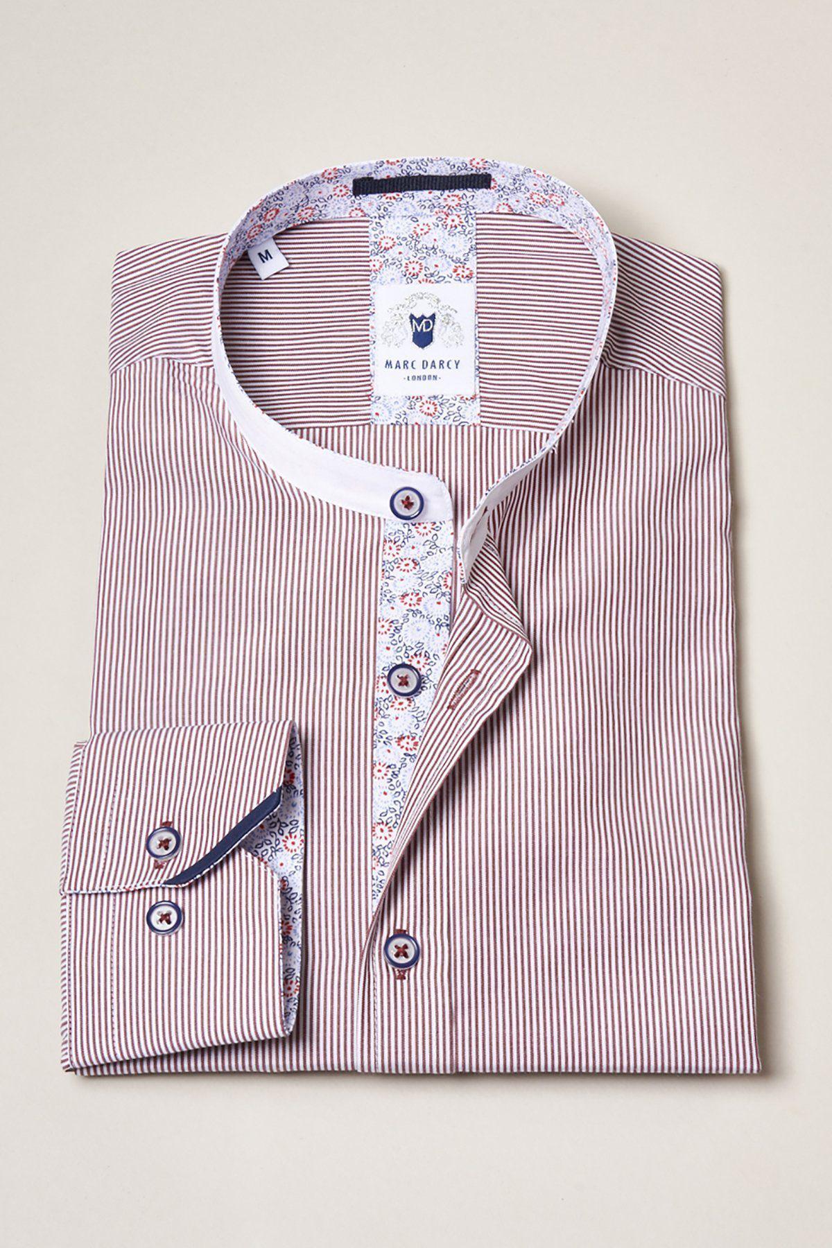 The COOPER Grandad Collar Wine Stripe Shirt by Marc Darcy features a vintage-inspired collar, red and white pinstripes, floral accents on the collar and placket, and contrasting buttons, displayed on a light beige surface.
