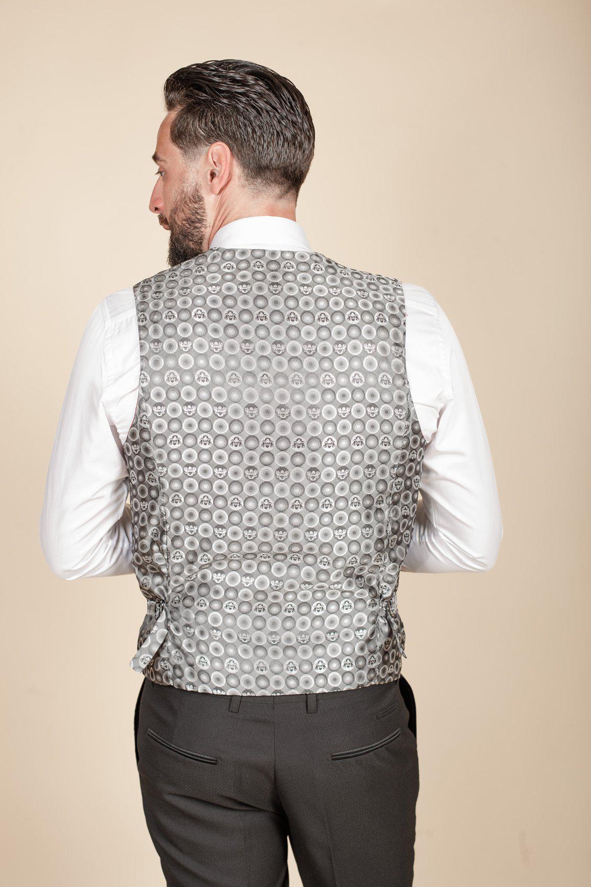 Owen Warner, 2022 runner-up of 'I'm A Celebrity Get Me Out Of Here,' is seen from the back wearing a Dalton Black Tuxedo by marcdarcy—featuring a grey patterned vest and white shirt, perfect for black tie events.