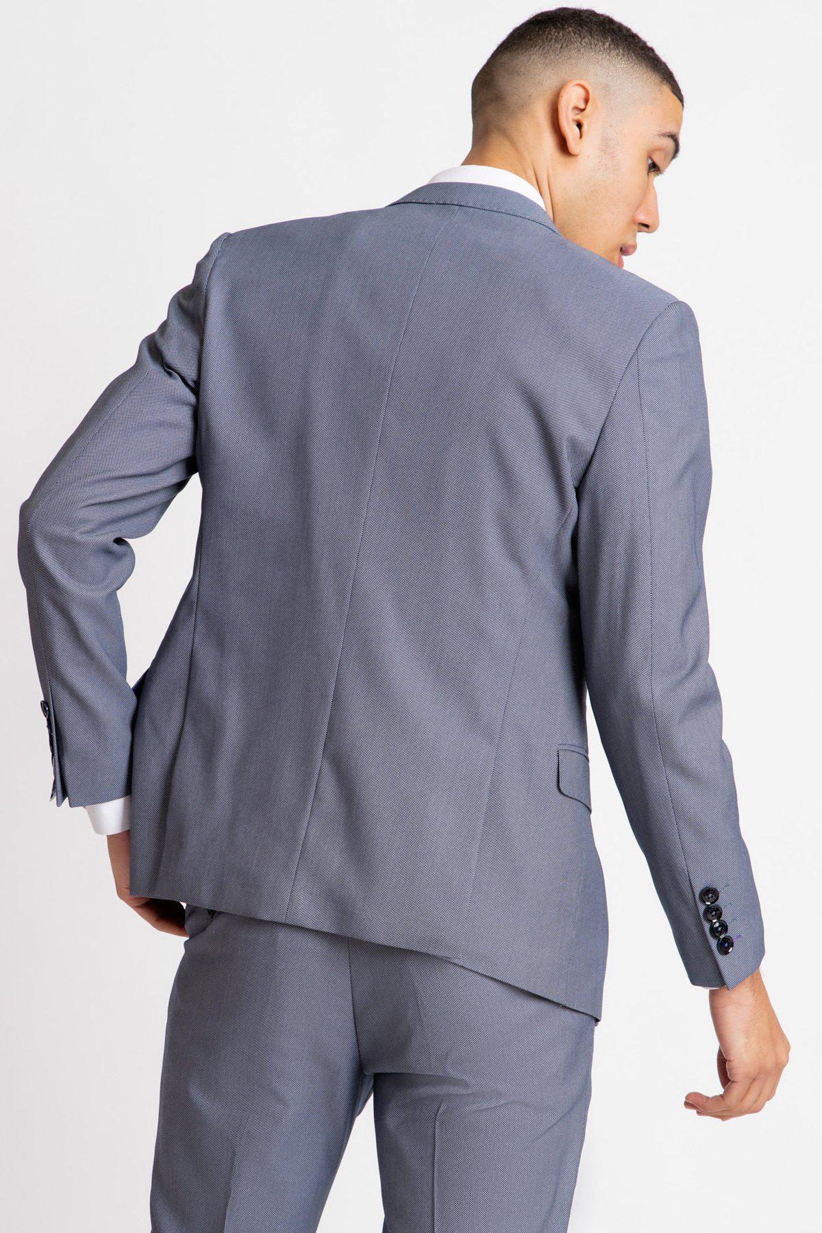 A man wearing the Marc Darcy DANNY Blue Grey Tailored Blazer, seen from behind with his left hand in his pocket.