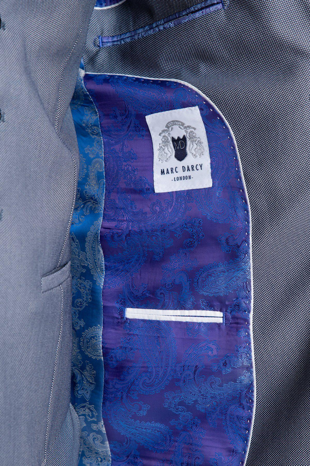 Close-up of the DANNY Blue Grey Tailored Blazer by Marc Darcy, featuring a purple and blue paisley lining, white label, and a small inner pocket with white trim—stylish details for a modern tailored look.