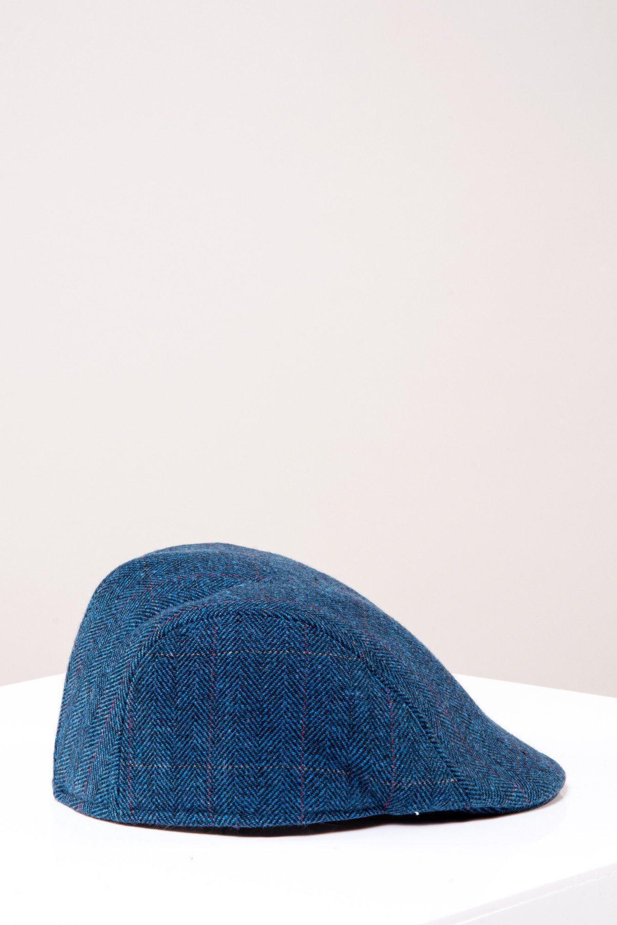 The DION - Blue Tweed Check Flat Cap by Accessory sits on a white surface with a plain, light-colored background.