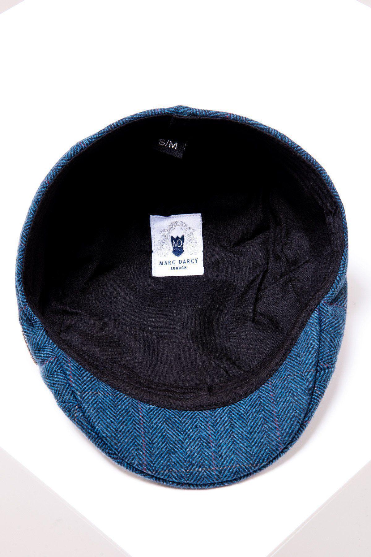 The DION - Blue Tweed Check Flat Cap by Accessory is shown from above, revealing its black inner lining, a white brand label, and an S/M size tag. This vintage-style cap rests on a white surface.