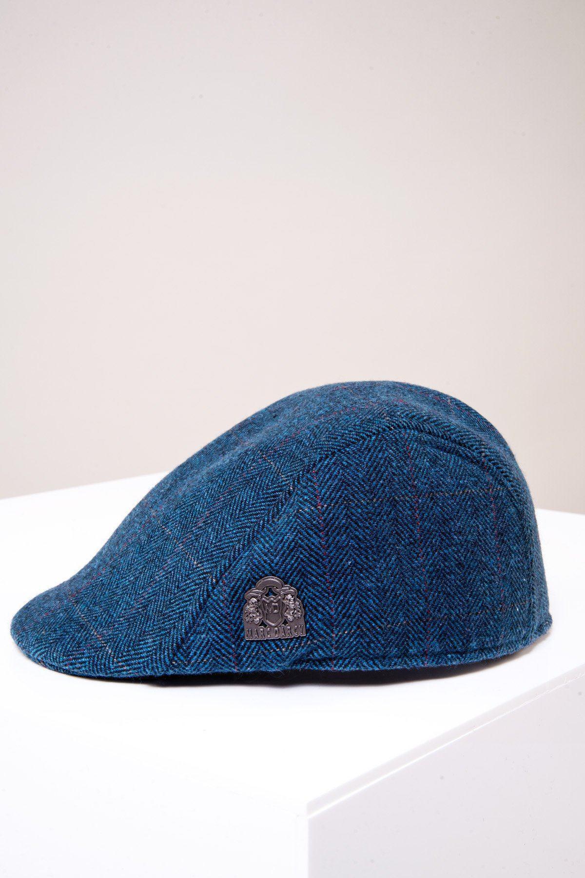 The DION Blue Tweed Check Flat Cap by Accessory, featuring a small metallic emblem on the side, is displayed on a white surface with a light background and channels classic Peaky Blinders style.
