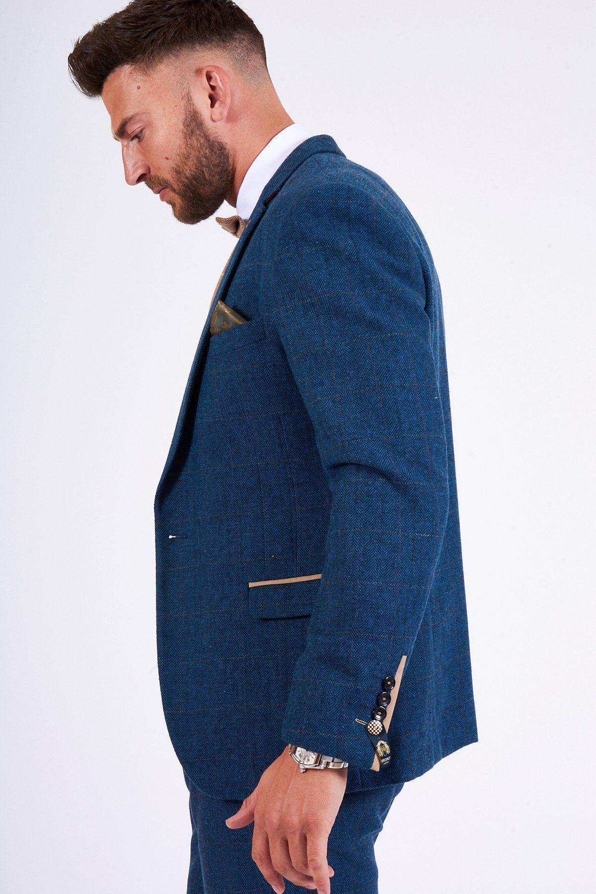 A man is pictured in a marcdarcy DION Blue Tweed Check Suit with DX7 Oak Waistcoat, paired with a tan pocket square and matching bowtie, shown from the side against a white background.