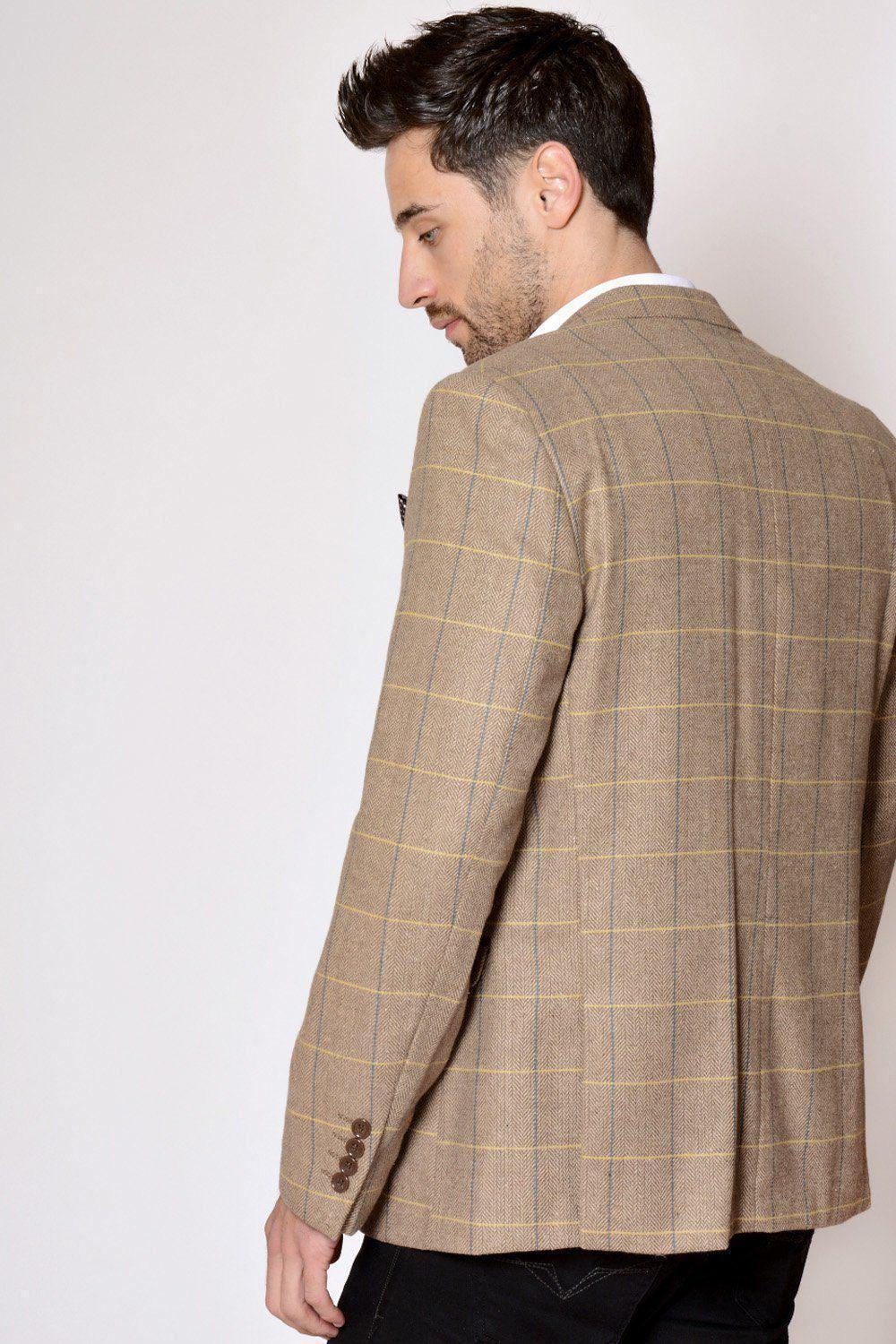 A man with short dark hair wears the marcdarcy DX7 - Oak Tweed Check Blazer, paired with black pants, standing with his back to the camera and glancing over his left shoulder against a plain light background.