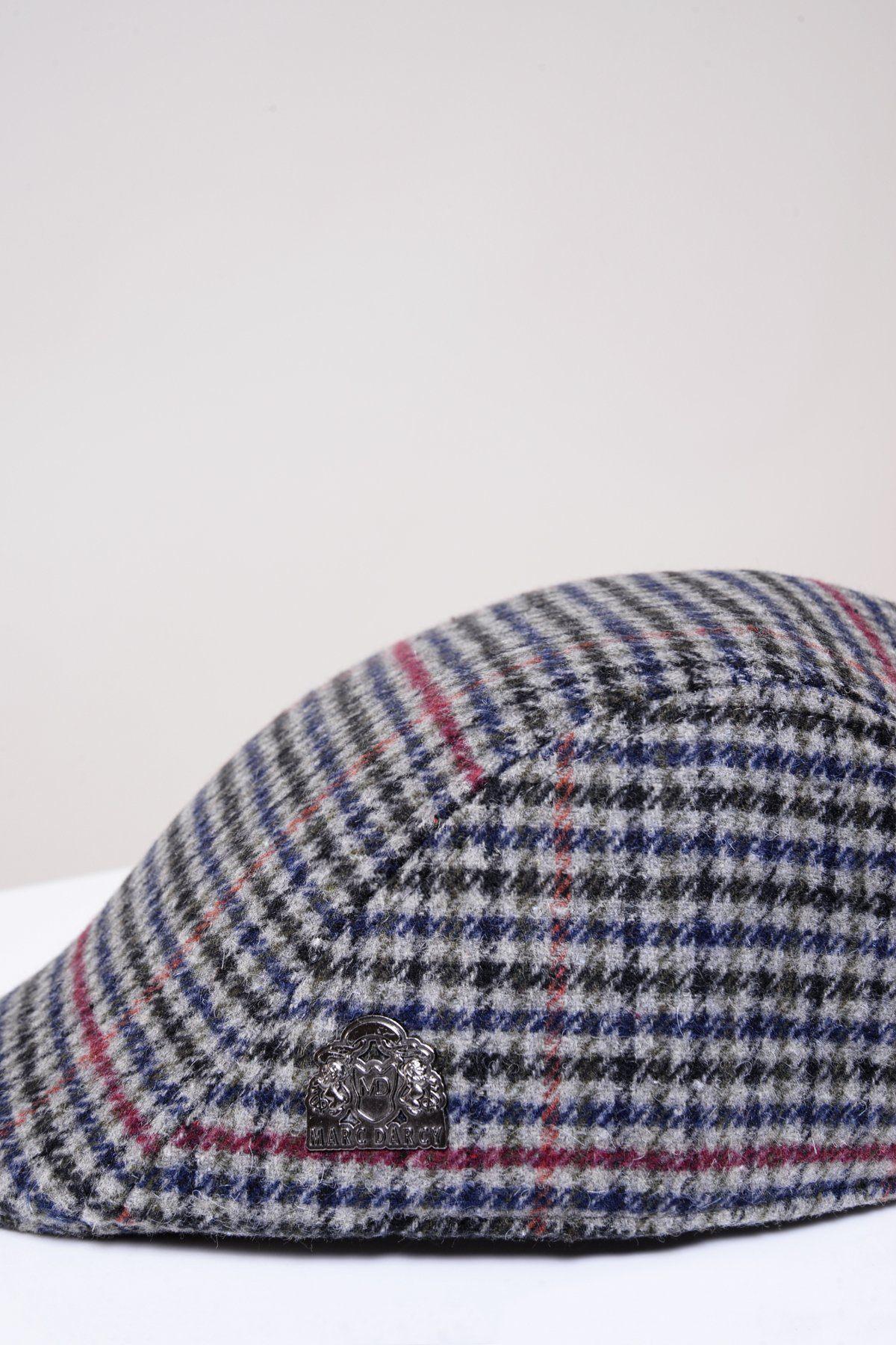 The EDWARD Navy Grey Check Tweed Flat Cap by Marc Darcy features a classic Peaky Blinders look with blue, grey, black, and red plaid plus a small metallic emblem—ideal for flat cap fans seeking timeless style. Set against a plain, light background.