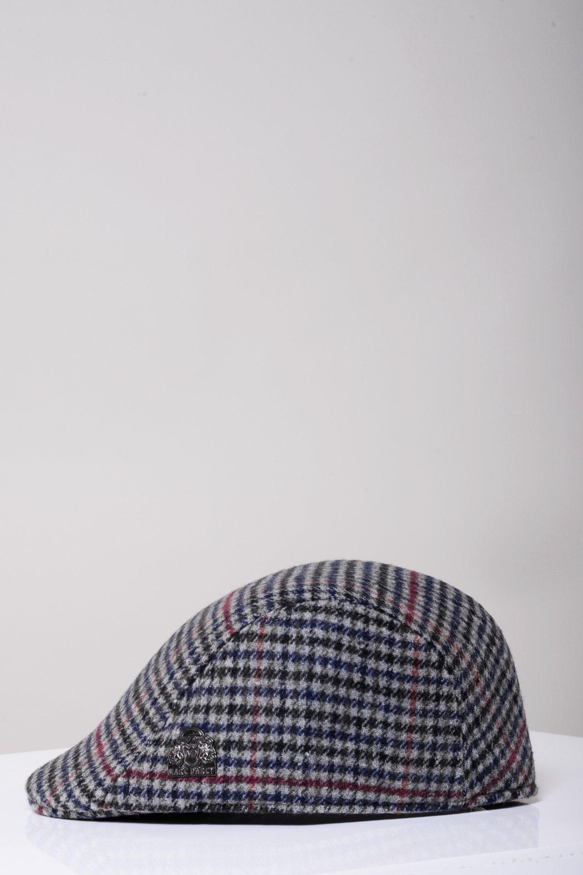 The Marc Darcy EDWARD Navy Grey Check Tweed Flat Cap, in Peaky Blinders style with a small metal emblem, is shown on a white surface against a light gray background.