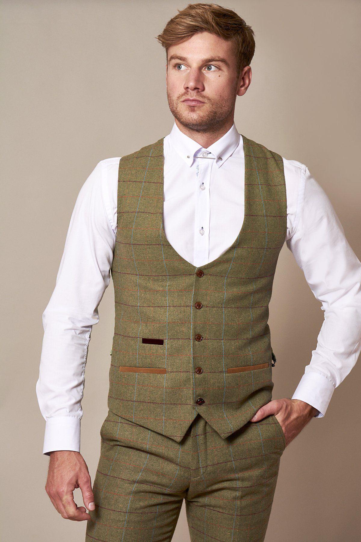 A man models the marcdarcy ELLIS - Moss Green Check Tweed Waistcoat with matching slim fit trousers and a white dress shirt against a beige background, channeling classic Peaky Blinders style as he gazes to the side, one hand in his pocket.