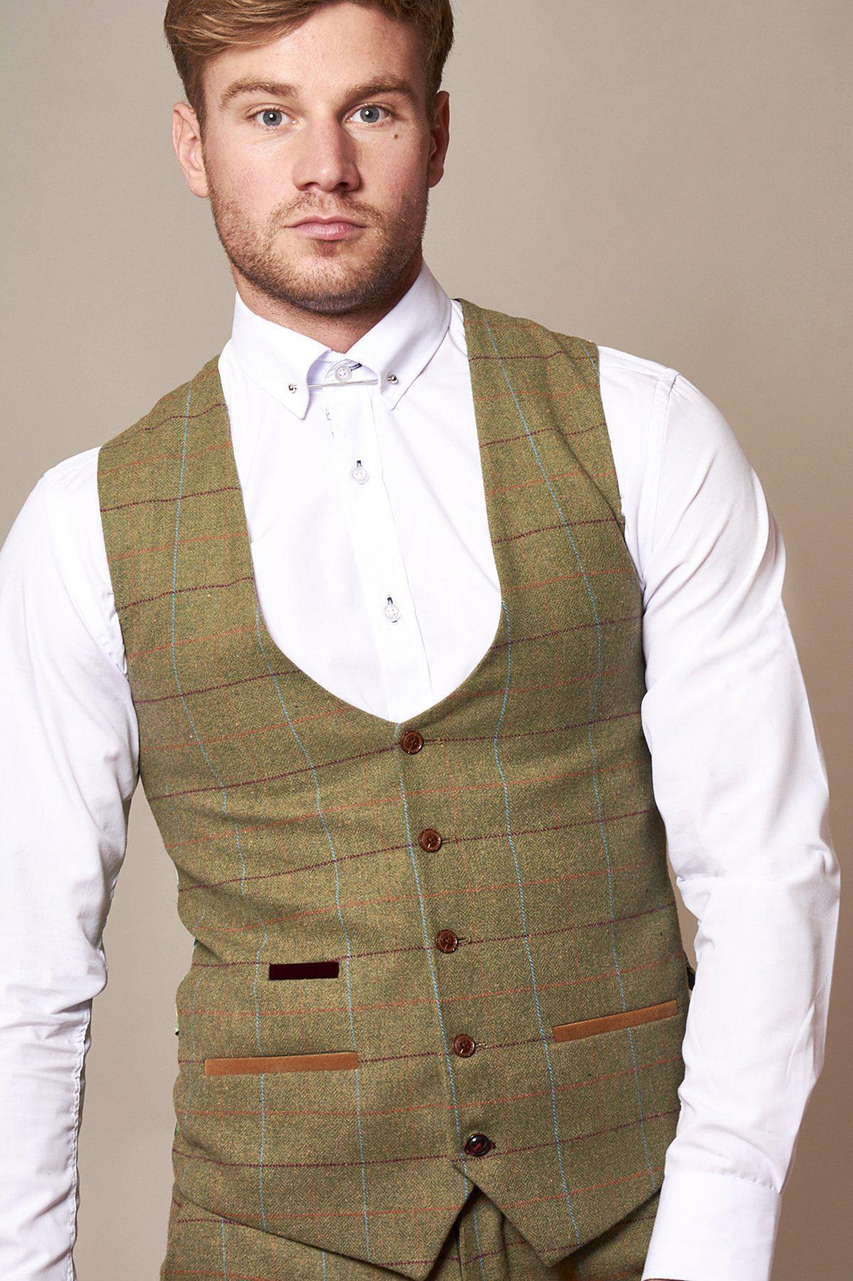 A man wearing a slim fit white dress shirt and the marcdarcy ELLIS Moss Green Check Tweed Waistcoat stands against a plain beige background.