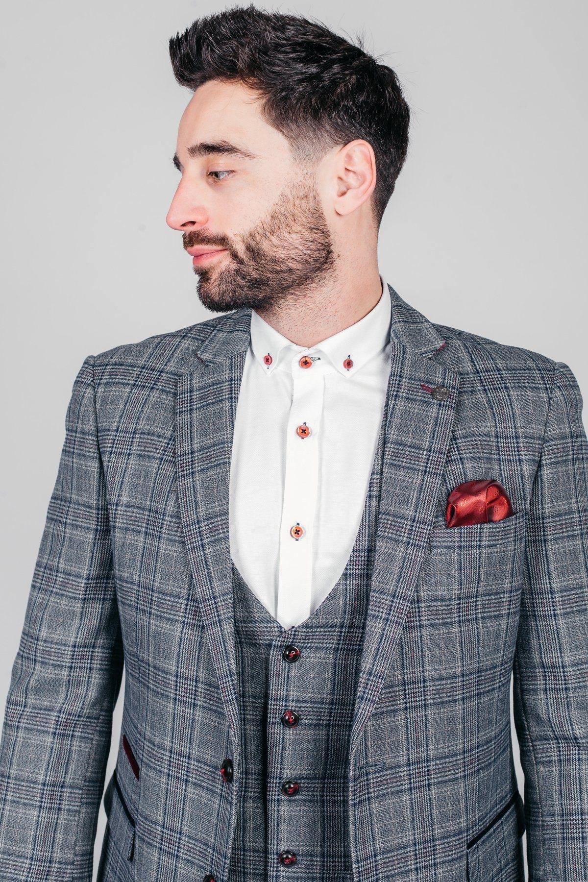 A man with dark hair and a beard wears the marcdarcy ENZO Blue Grey Tweed Check Blazer with a white shirt, red buttons, and a red pocket square. He looks left against a plain light background.