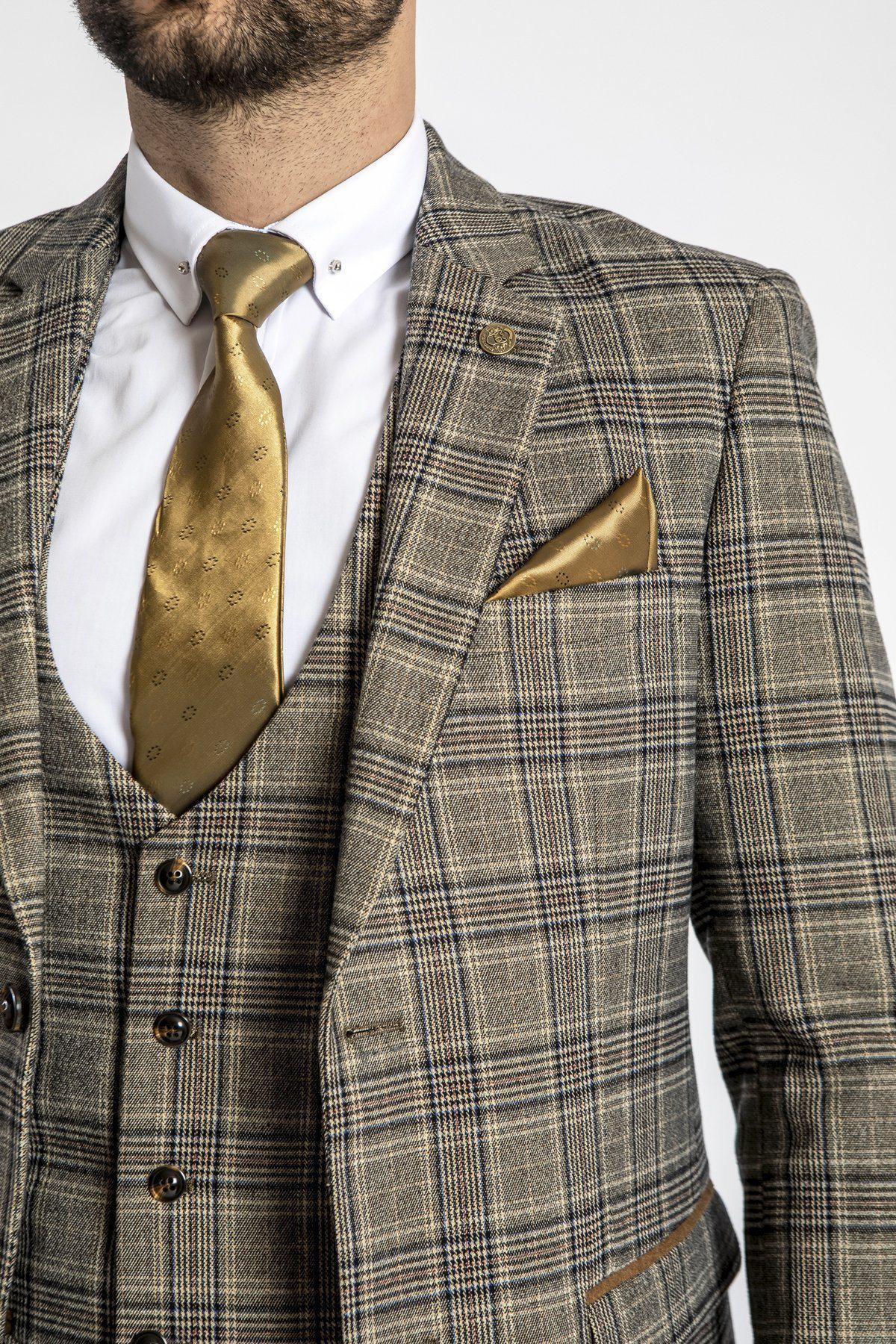 A man wearing the marcdarcy ENZO Tan Tweed Check Blazer with a matching vest, white dress shirt, gold tie, and pocket square. The Peaky Blinders-inspired look shows his upper body and part of his face.