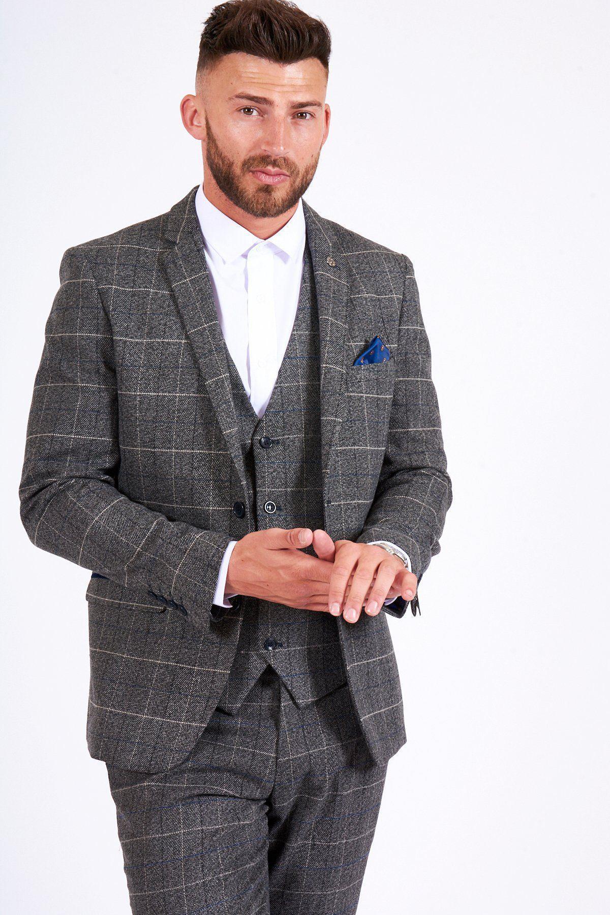 Former Arsenal midfielder Gilberto Silva wears the marcdarcy Scott Grey Tweed Check Blazer & Waistcoat, styled with a white shirt and blue pocket square, his hands clasped in front.