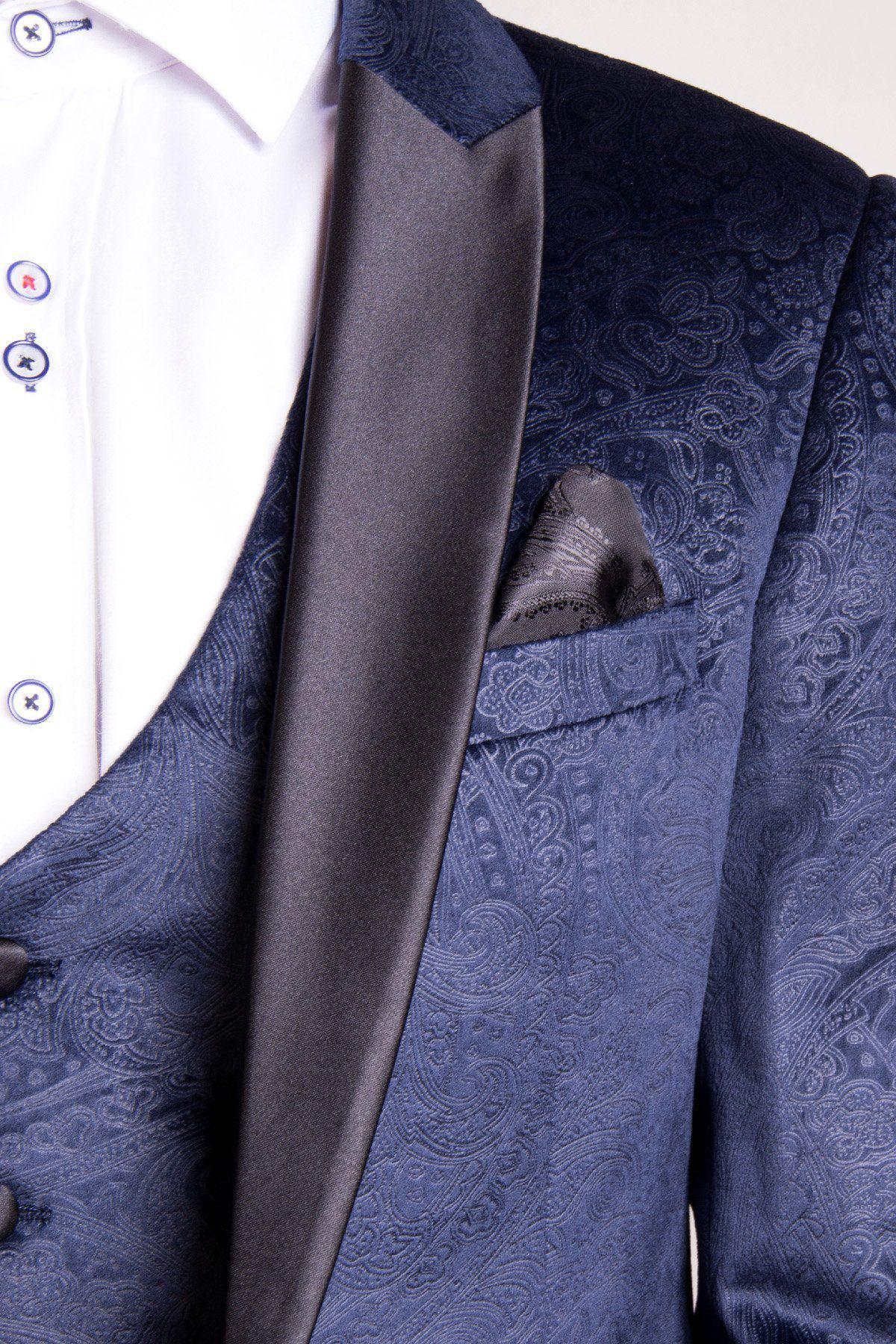 Close-up of Coronation Street’s Will Mellor (Harvey Gaskell) in the Marc Darcy Simon Velvet Blazer & Waistcoat, featuring a slim tailored fit with blue paisley pattern, black satin lapels, matching pocket square, and white dress shirt.