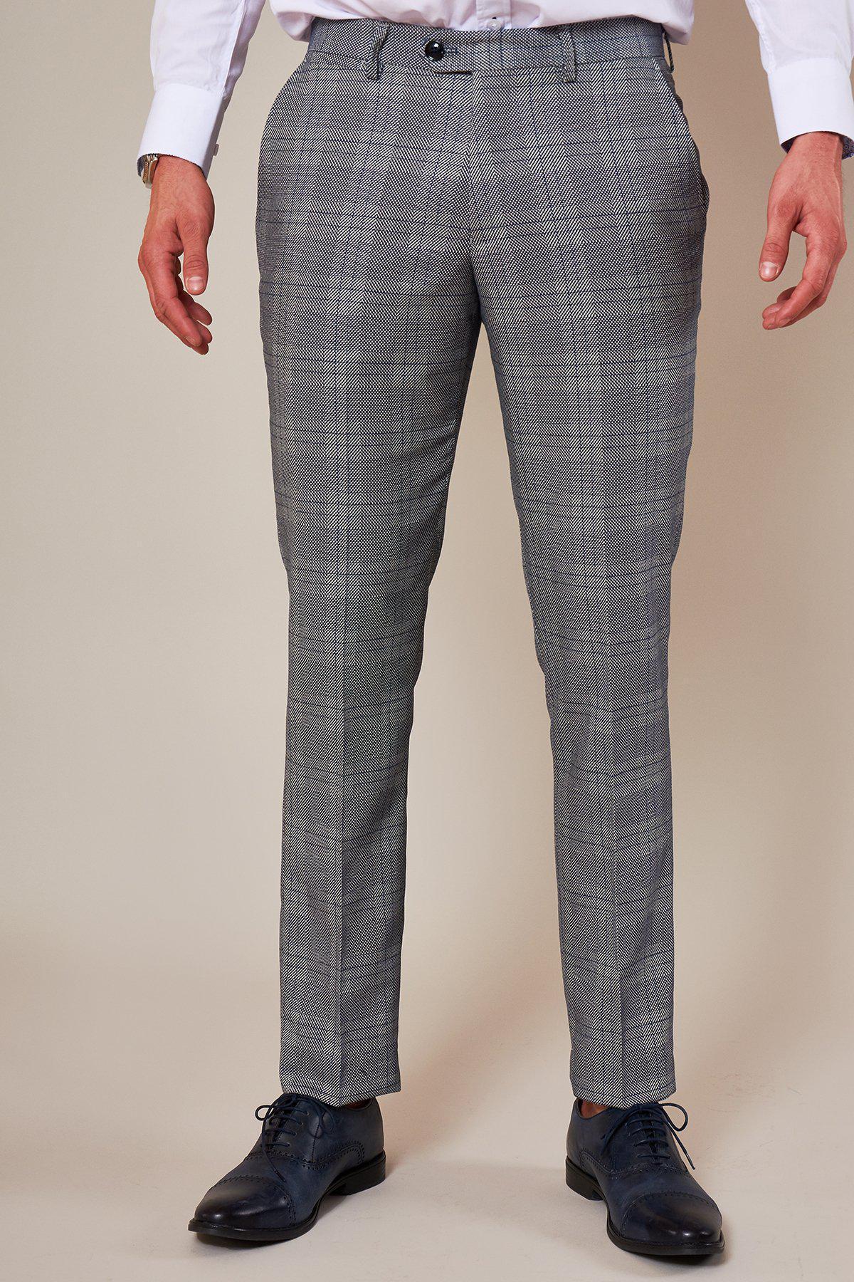 Oliver Norwood wears the marcdarcy Jerry Check Suit from The Sheffield Utd Collection, pairing a white shirt with slim grey check trousers and dark blue dress shoes.