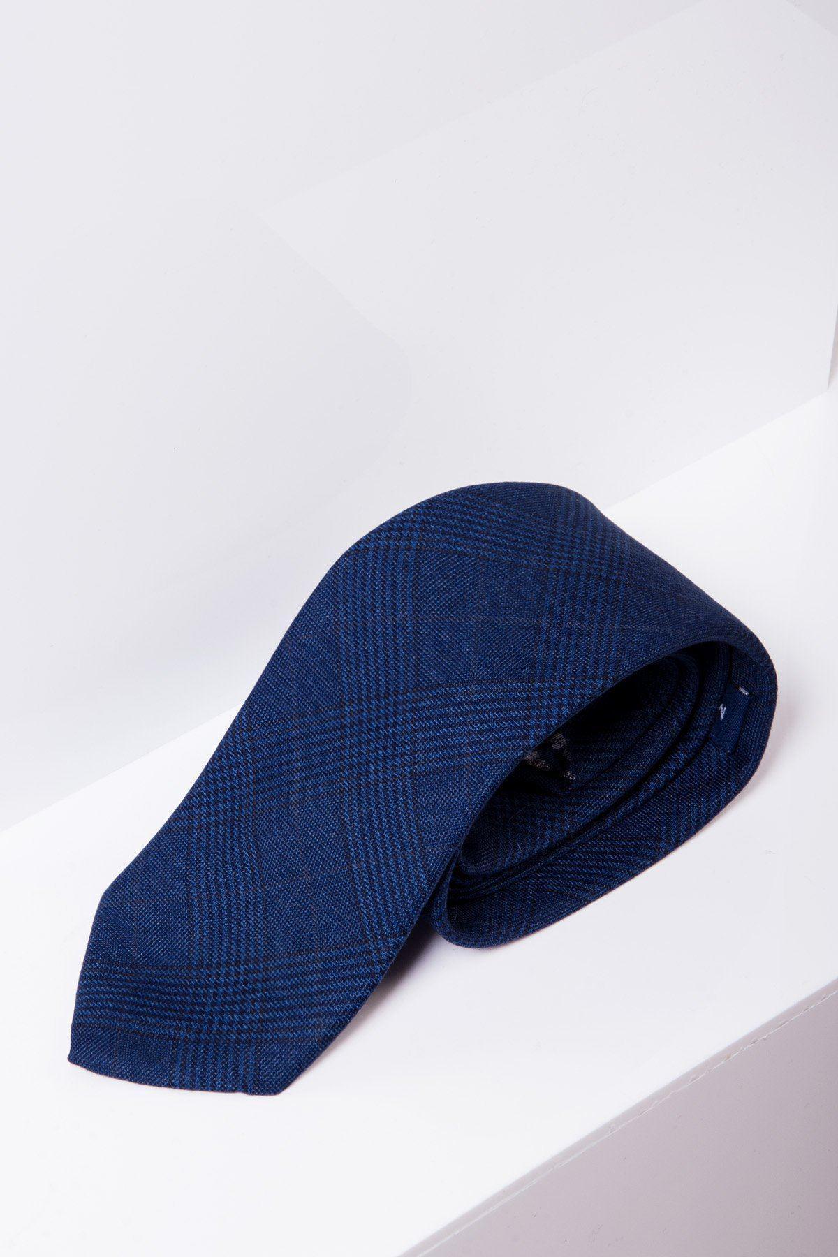 The GEORGE - Royal Blue Check Tie by Accessory, featuring a subtle black plaid pattern inspired by the Prince of Wales check, rests on a white surface.