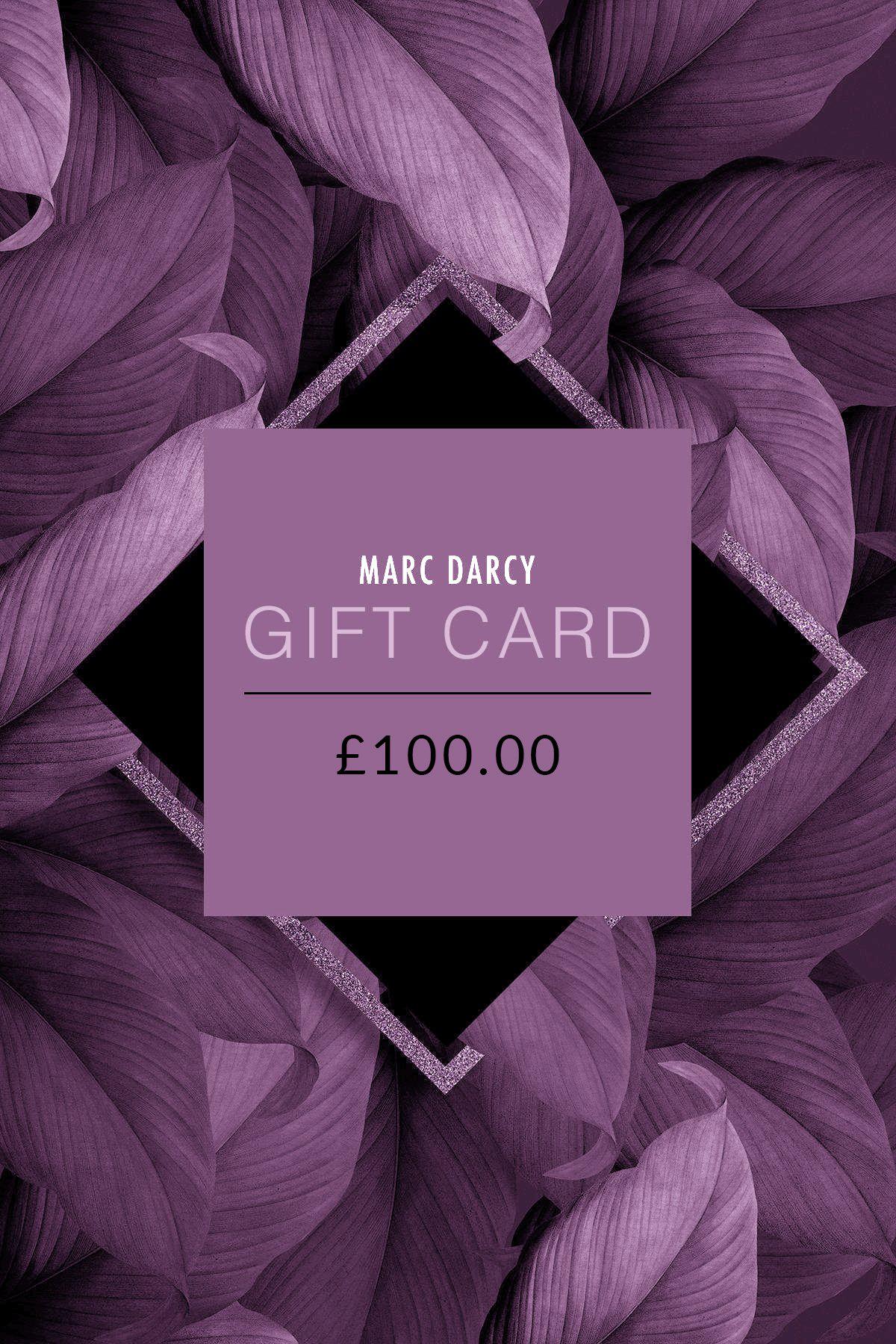 The £100 Marc Darcy Gift Card is displayed on a background of purple leaves with a geometric frame, making it an ideal gift for any occasion.