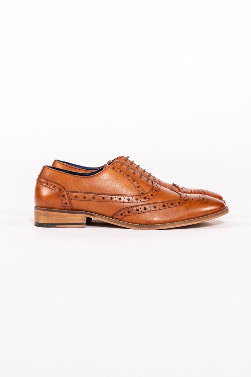The Marc Darcy GRAYSON Tan Leather Wingtip Brogue Shoe features decorative perforations, closed lacing, and a low stacked heel, shown in profile against a white background.