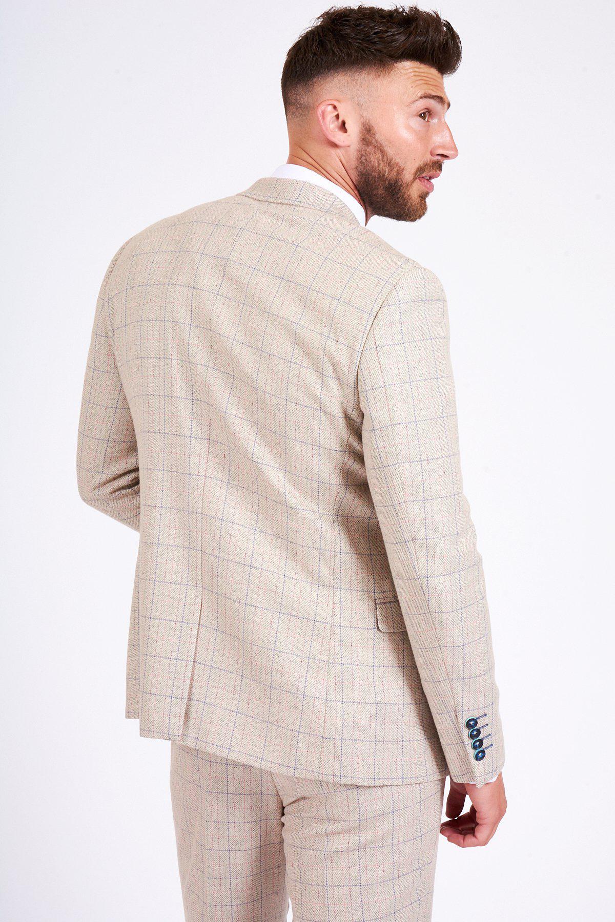 A man with short hair and a trimmed beard stands turned to the side, wearing the marcdarcy HARDING Cream Tweed Check Print Blazer with blue cuff accents against a plain white background.
