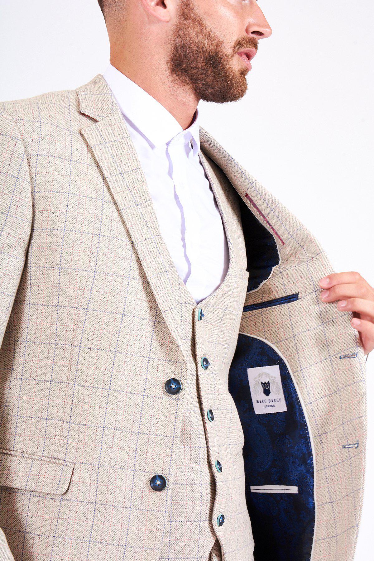 A man in a cream marcdarcy HARDING Tweed Check Print Blazer and white shirt holds open his jacket to reveal a blue patterned lining and brand label. His face is partially out of frame, highlighting spring style details.