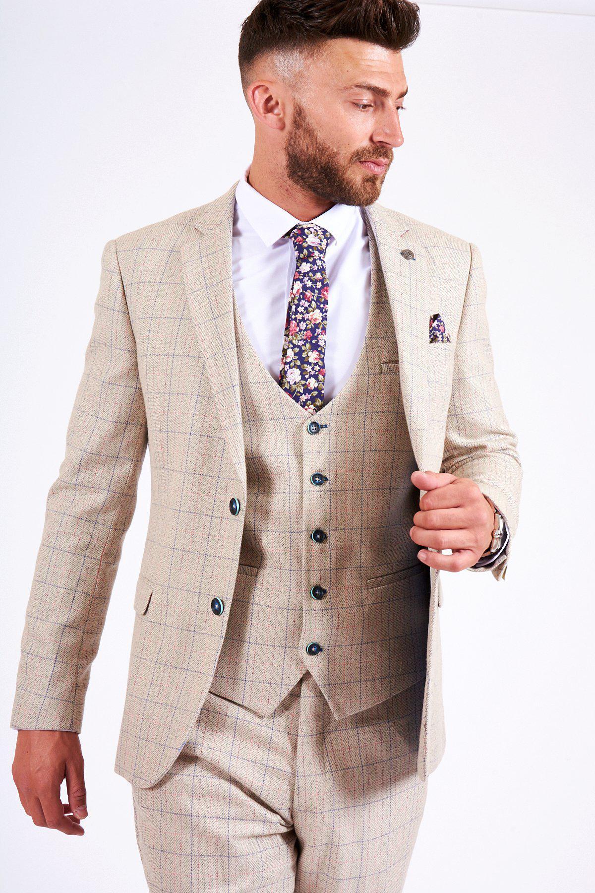 A man models the marcdarcy HARDING Cream Tweed Check Print Blazer with a floral tie and pocket square, presenting fresh spring styling against a white backdrop.