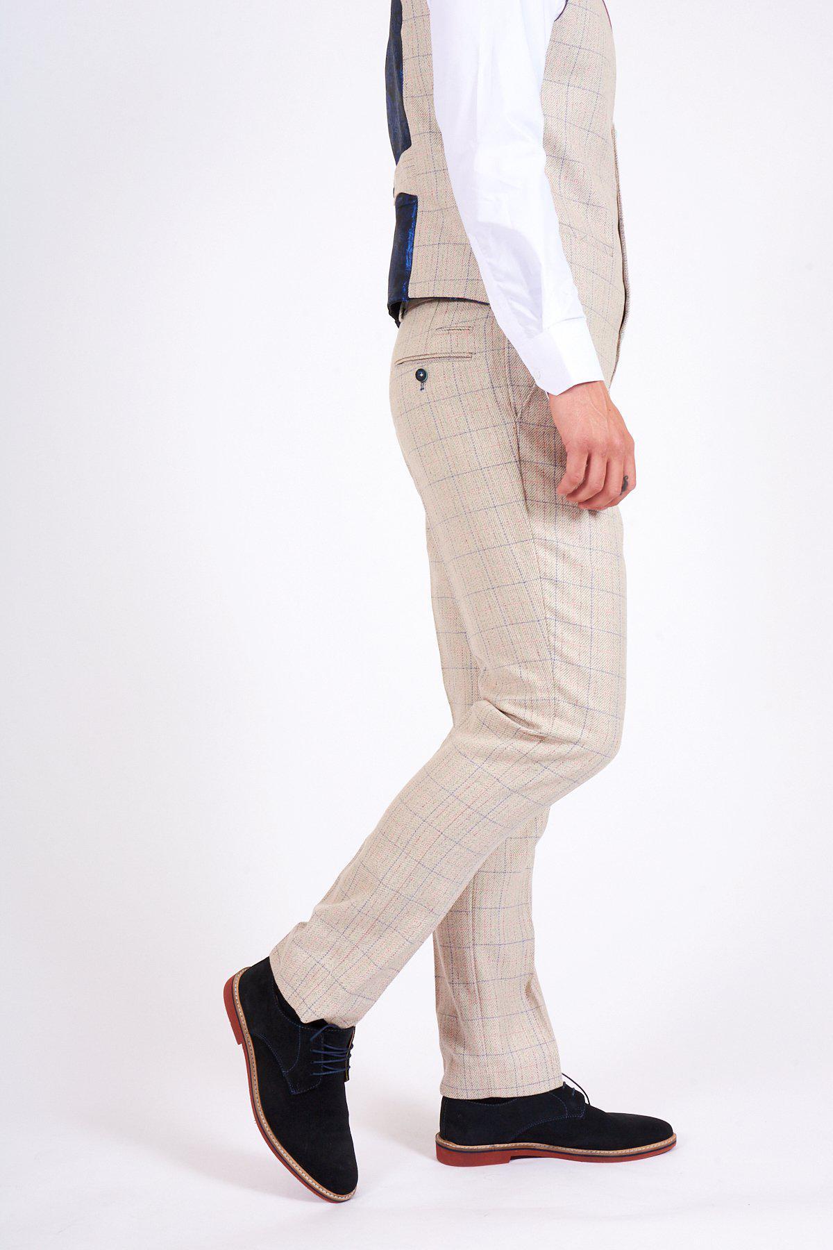 A person stands in profile against a plain white background, wearing marcdarcys HARDING Cream Tweed Check Print Trousers with a beige plaid suit, matching vest, white shirt, and black shoes—a perfect look for spring styling.