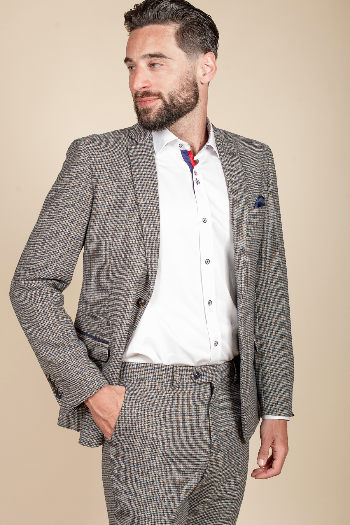 A bearded man wears the marcdarcy HARDWICK Navy Tan Tweed Check Blazer with a white shirt featuring navy buttons, red trim detail, and a navy pocket square.