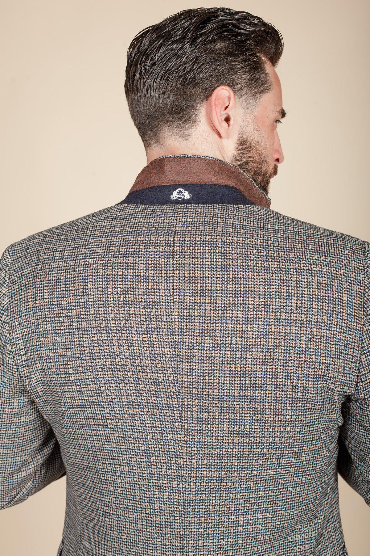 Rear view of a man wearing the marcdarcy HARDWICK Navy Tan Tweed Check Blazer, featuring a slim fit, dark blue collar, brown lapel, and an embroidered logo highlighting its stylish details.