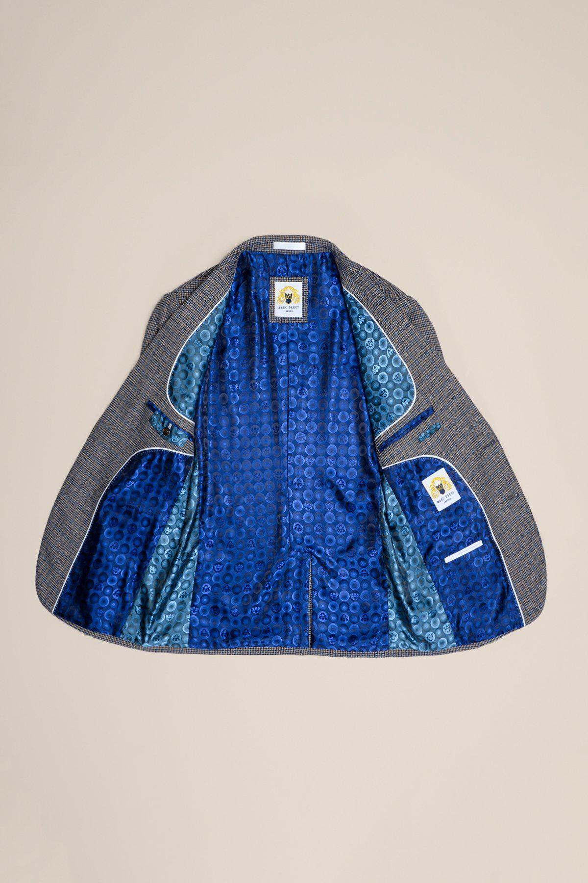 The HARDWICK Navy Tan Tweed Check Blazer by marcdarcy is displayed flat and open, revealing its bold blue patterned lining featuring the marcdarcy London logo.