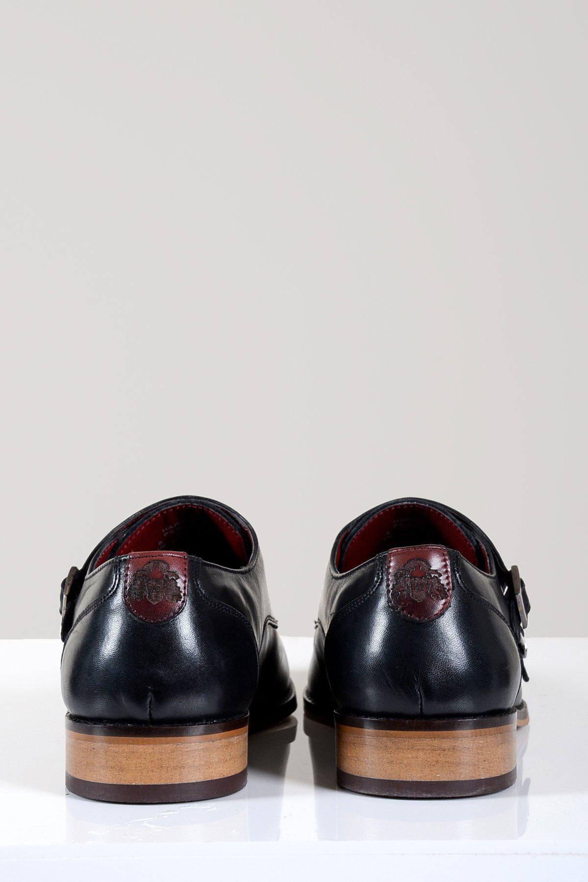 The Marc Darcy HARRIS Black Leather Double Strap Monk Shoes are crafted from full grain leather with wooden soles, brown heel patches, and vibrant red linings, shown from the back on a white surface.