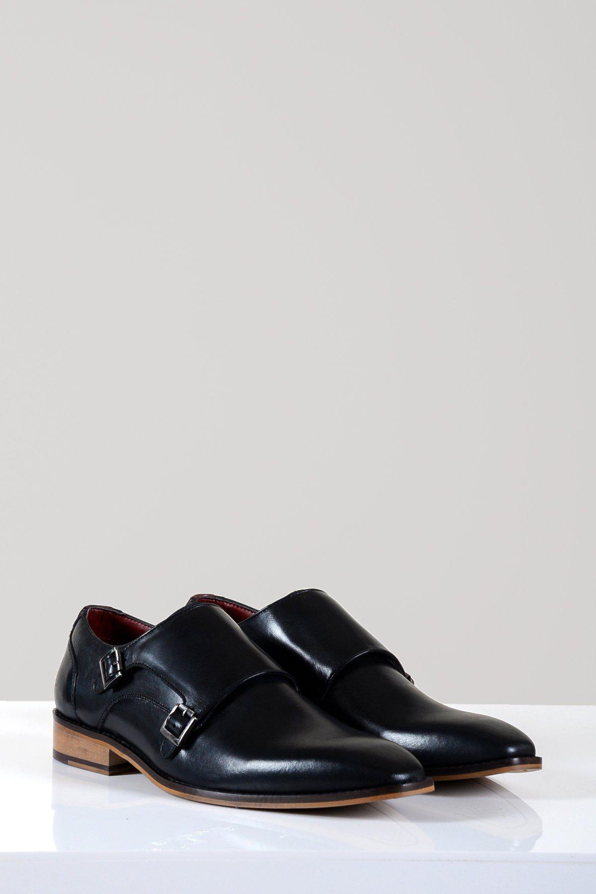 The Marc Darcy HARRIS Black Leather Double Strap Monk Shoe features full grain leather, silver buckles, and brown soles, displayed on a white surface with a light gray background.