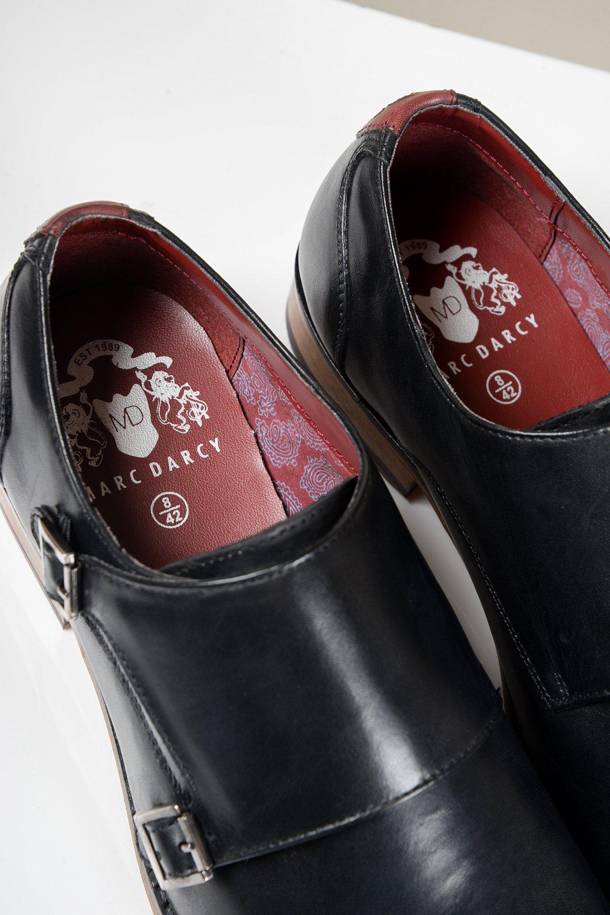 Close-up of two black HARRIS Double Strap Monk Shoes by Marc Darcy, crafted from full grain leather with maroon insoles featuring the Marc Darcy est. 1989 logo.