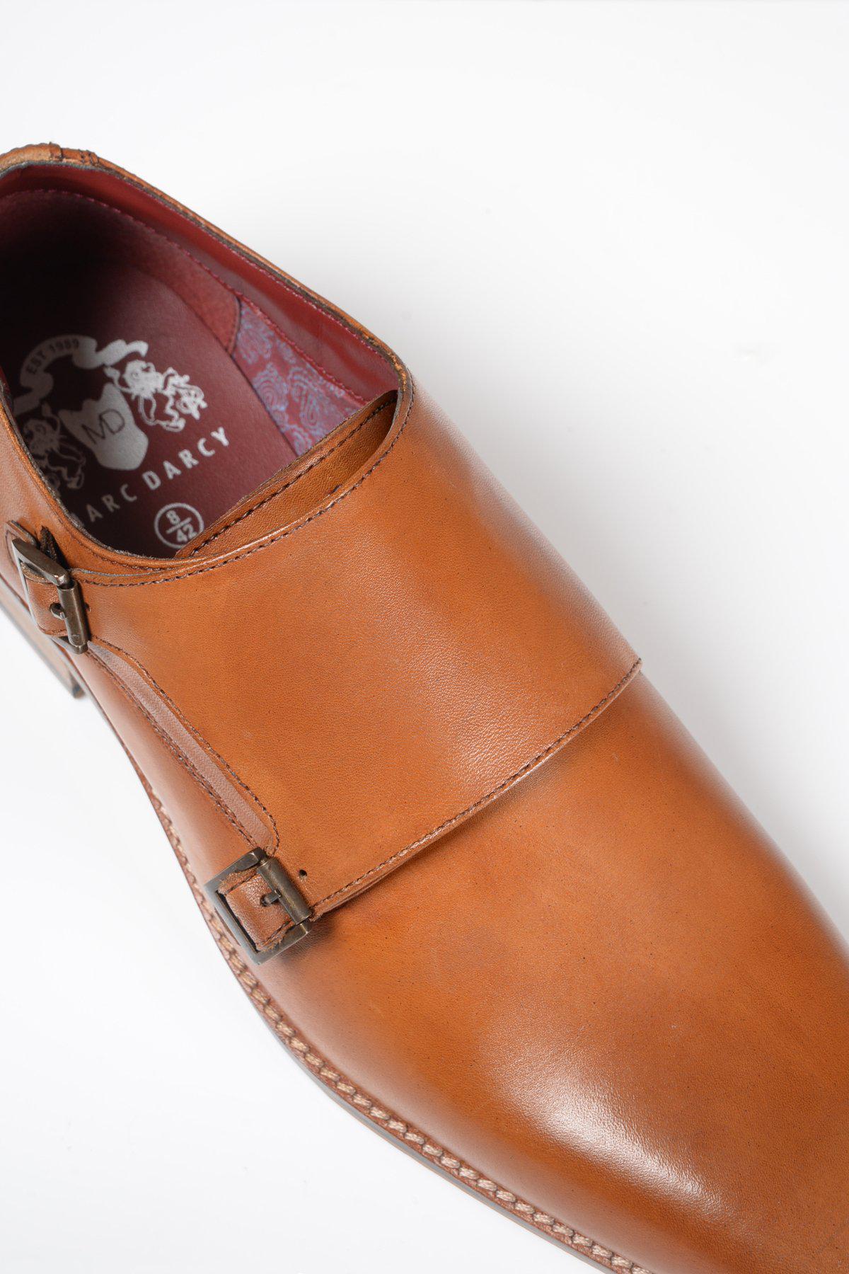 Close-up of the Marc Darcy HARRIS - Tan Leather Double Strap Monk Shoe with double buckle, rounded toe, hand-stitched detailing, patterned inside lining, and brand logo.
