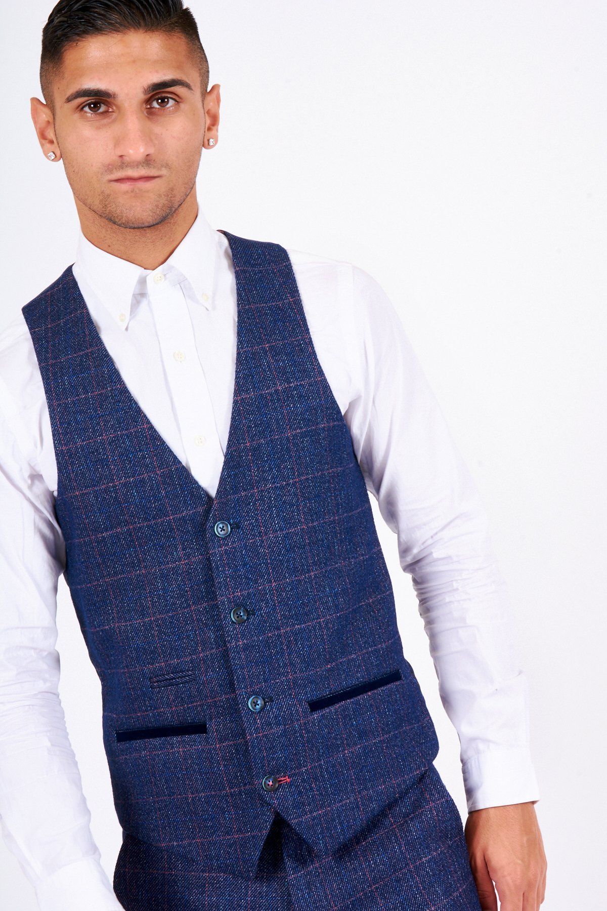 A person stands confidently against a white background wearing the marcdarcy HARRY Indigo Single Breasted Tweed Check Waistcoat, paired with matching pants and a white dress shirt.