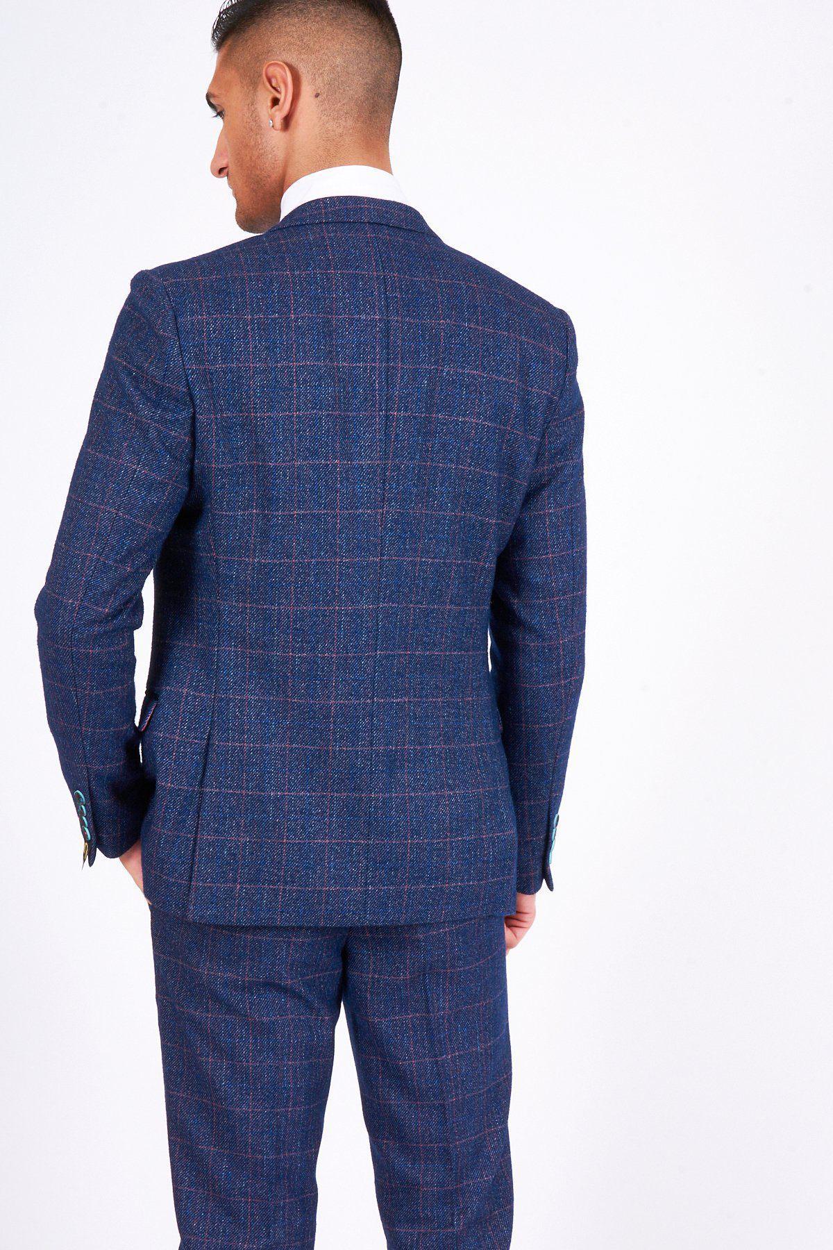 A man wears the marcdarcy HARRY Indigo Tweed Check Blazer, perfect for weddings, with a white collared shirt. He stands with his back to the camera, facing slightly left, showcasing the blazers subtle check pattern.