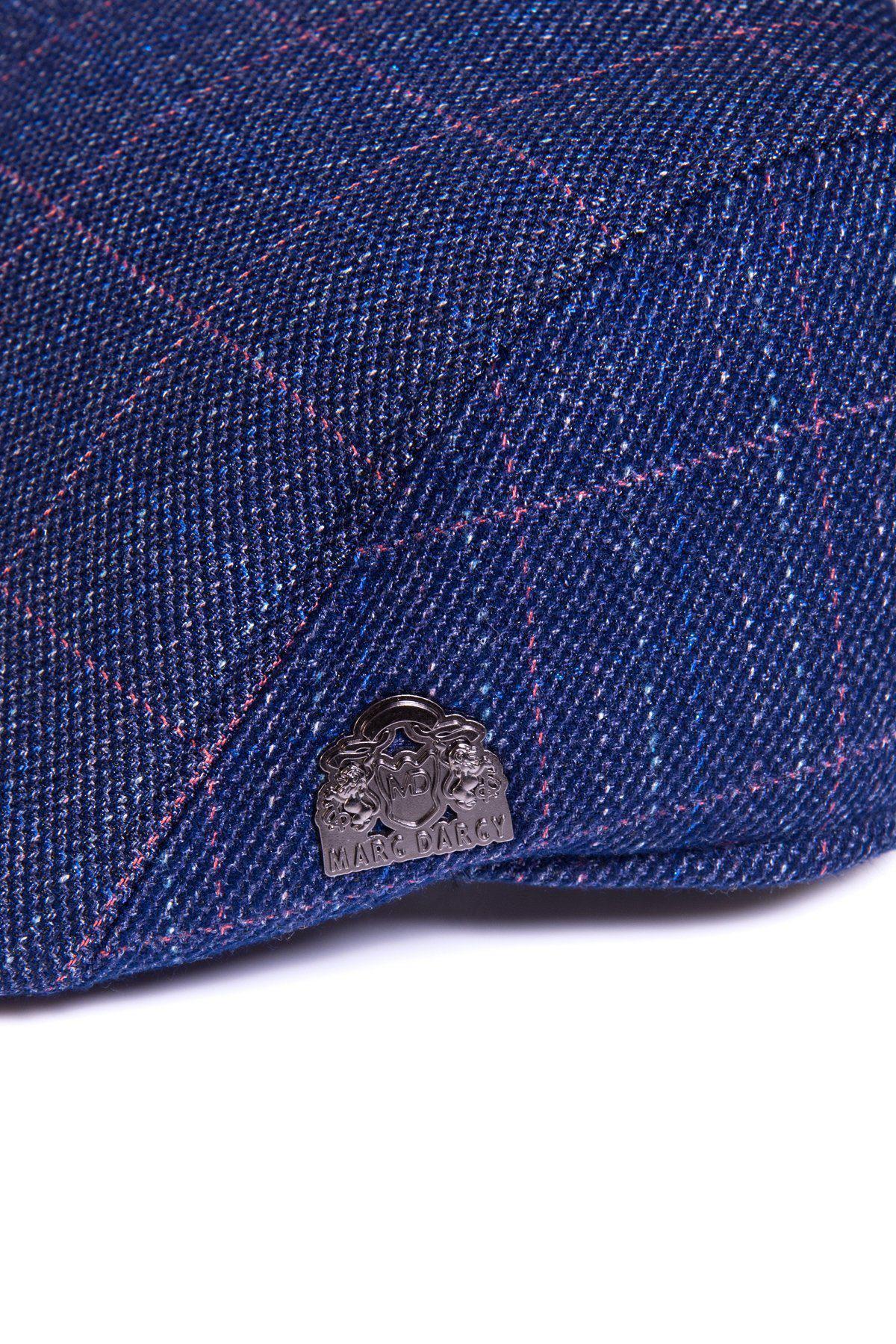 Close-up of the HARRY - Indigo Tweed Check Flat Cap by Accessory, showing blue tweed with thin red grid lines and a small metallic badge on the side for vintage flair.