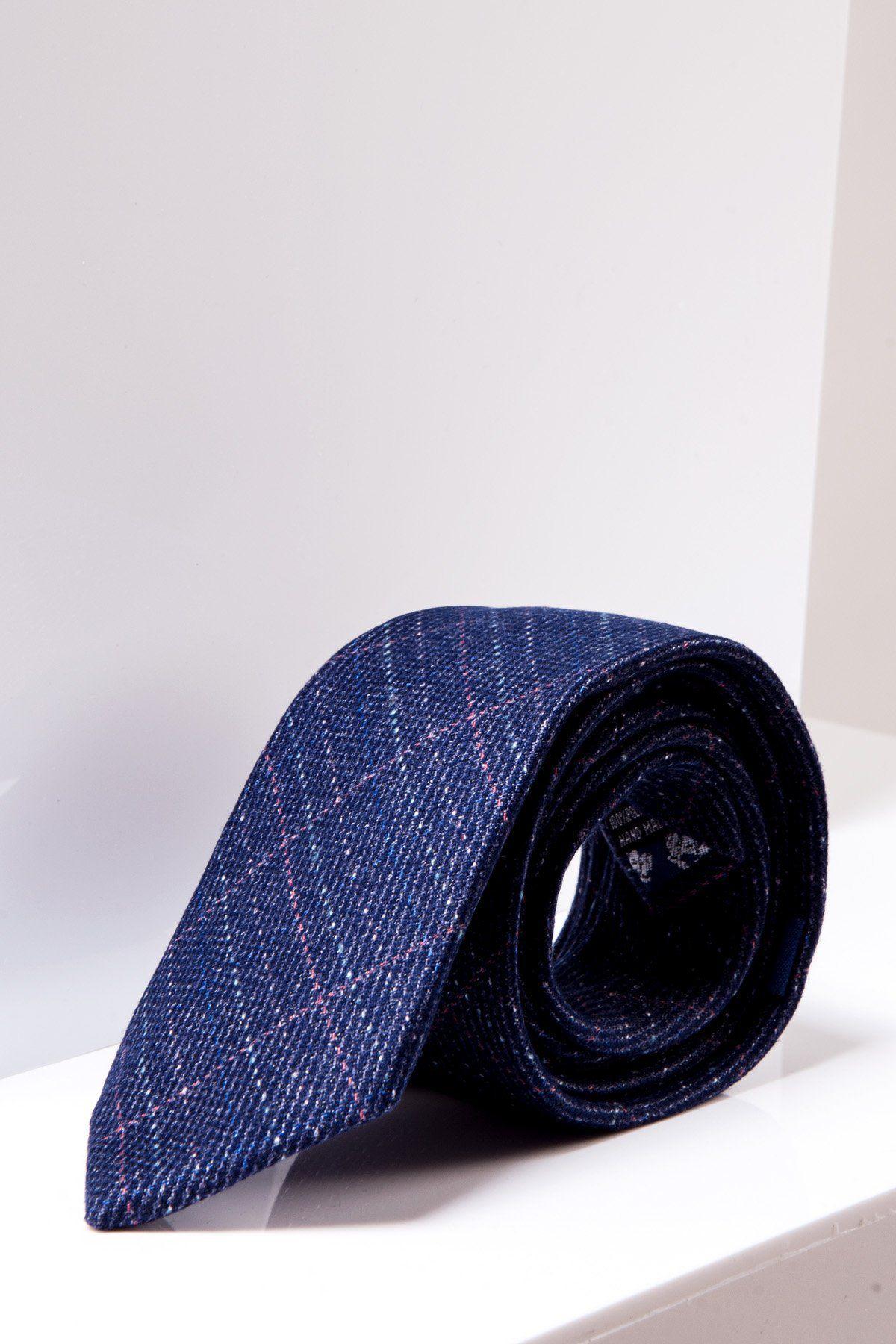 The marcdarcy HARRY - Indigo Tweed Check Tie features a rolled-up luxury design with a subtle plaid pattern and thin pink lines, making it ideal for formal occasions. Displayed on a white surface against a white background.