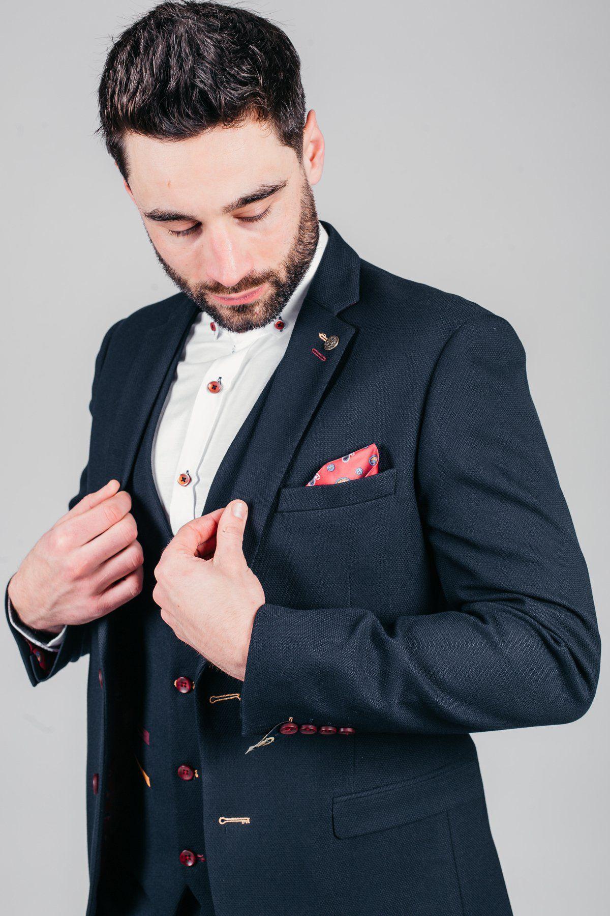 Former Sheffield United footballer Brian Deane wears the marcdarcy JD4 Navy Blazer, featuring a white shirt and red accents, adjusting his jacket to reveal a red pocket square and matching buttons.