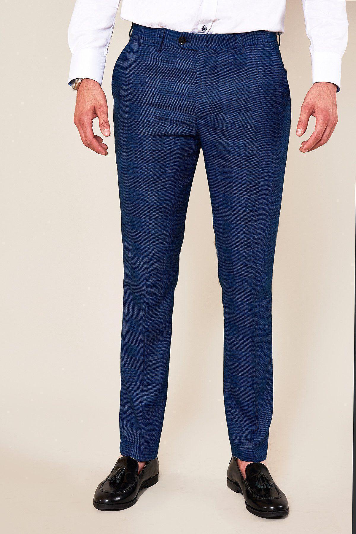 A man in a white shirt stands wearing marcdarcy JERRY Skinny Fit Blue Check Trousers and black tassel loafers.
