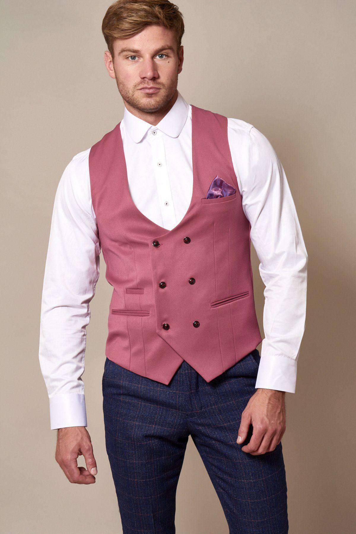 A man in a white shirt, dark checkered trousers, patterned pocket square, and the marcdarcy KELLY Pink Double Breasted Waistcoat with purple paisley lining stands against a neutral background—ideal inspiration for bridesmaids’ looks.