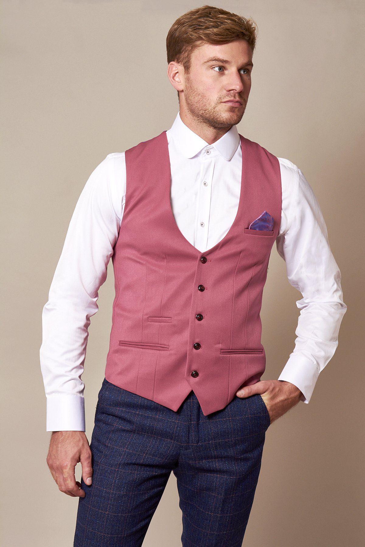 A man wears the marcdarcy KELLY Pink Single Breasted Waistcoat over a white shirt and dark blue plaid pants, with a purple pocket square in his pocket—an ideal choice for a stylish wedding look.