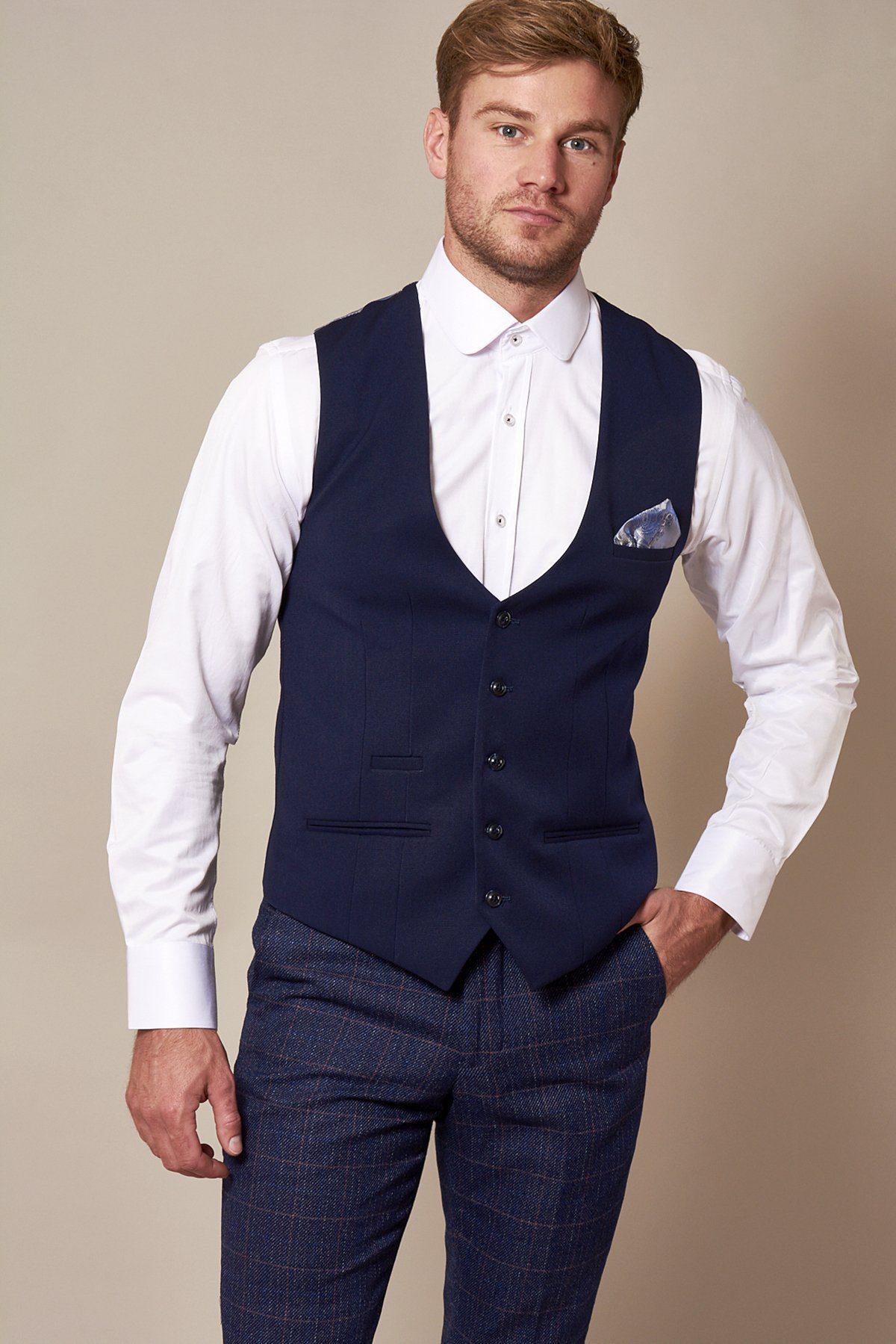Man in a marcdarcy KELLY Royal Blue Single Breasted Waistcoat, white rounded collar dress shirt, plaid trousers, and blue pocket square visible in the waistcoat pocket.