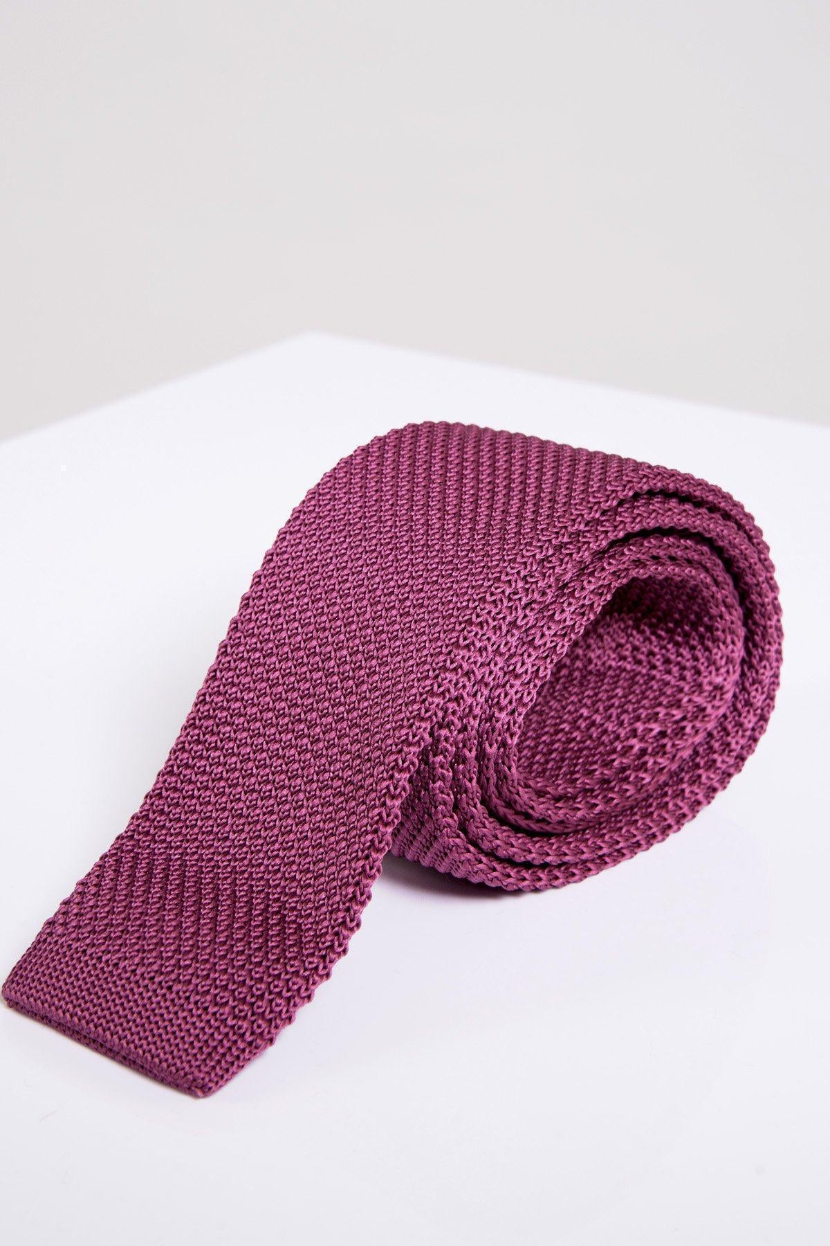 The Accessory KT - Berry Knitted Tie, featuring rolled-up textured knit, is displayed on a white surface against a light gray background—a stylish choice for spring and summer occasions.