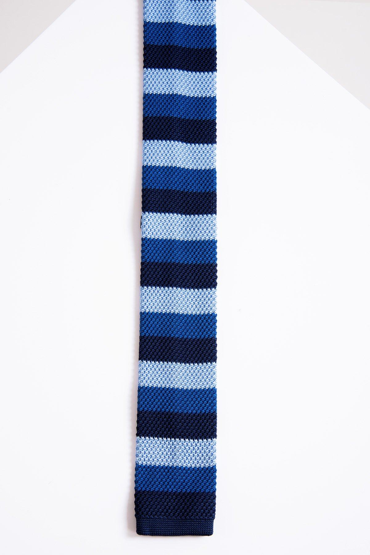 The Accessory KT - Blue Stripe Knitted Tie in navy, royal, and light blue lays vertically on a white surface—an elegant contemporary tie ideal for office wear.