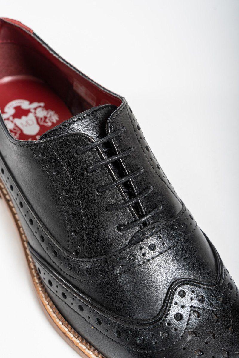 Close-up of the Marc Darcy LARKIN black leather brogue shoe, featuring decorative perforations, black laces, a brown outer sole, red inner lining with white logo. Expertly hand-crafted from premium full grain leather.