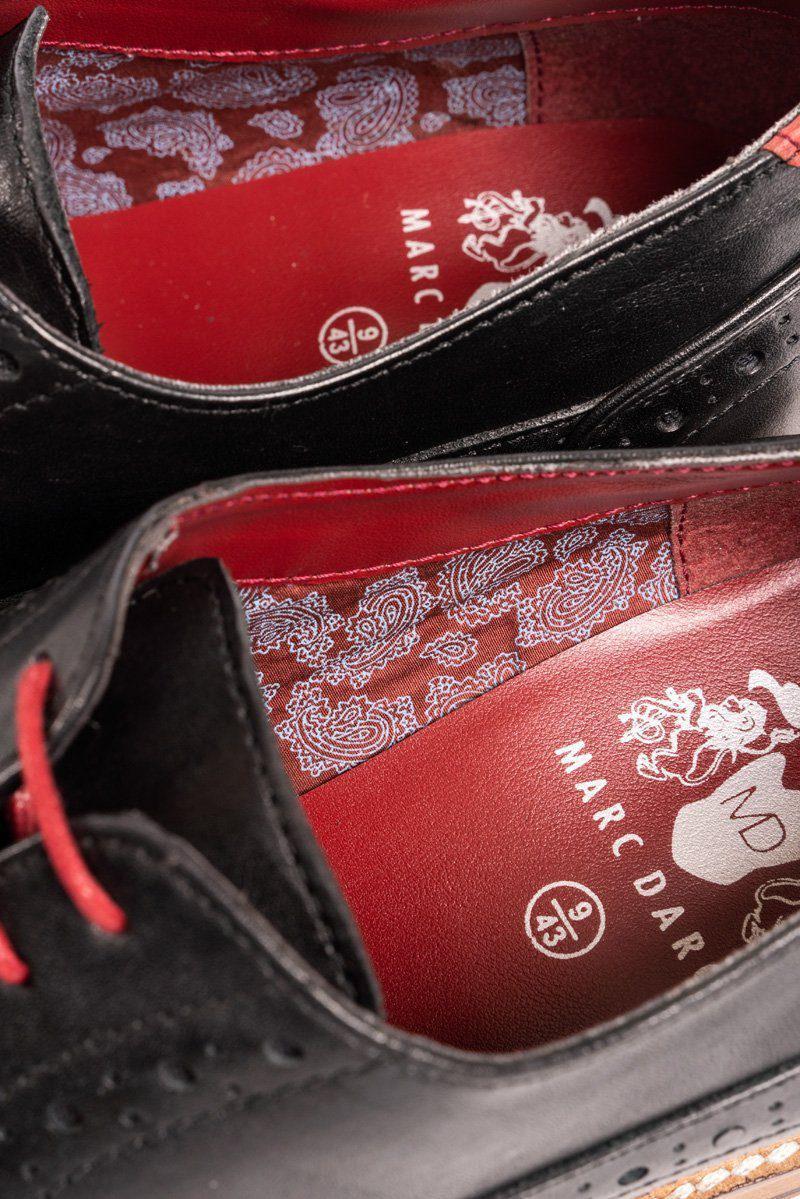 Close-up of LARKIN black leather brogue shoe by Marc Darcy, featuring red soles, red laces, paisley lining, and hand-stitched details. Size 9/43 and branding visible.
