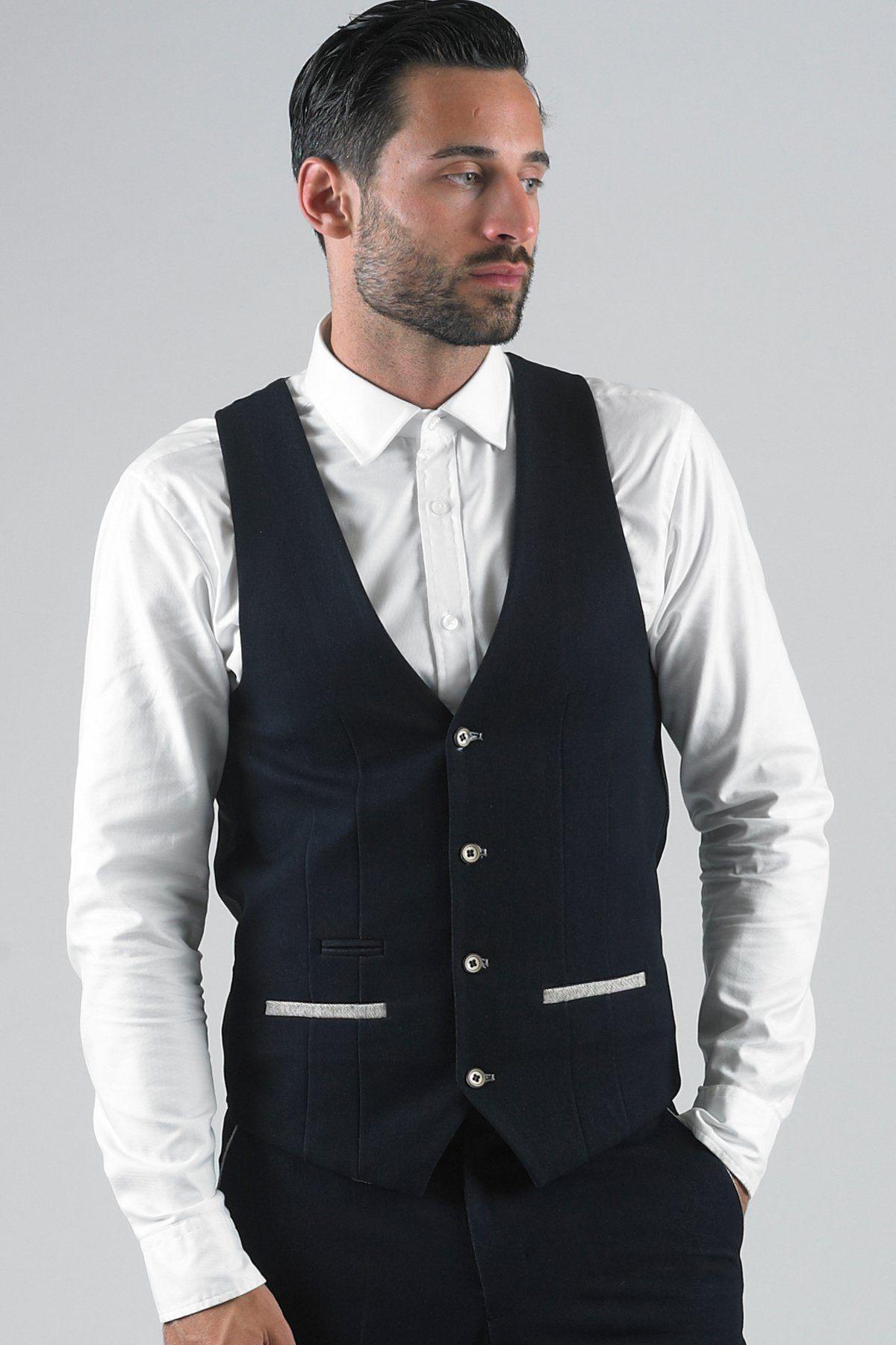 A man with dark hair and a short beard wears a white dress shirt and the marcdarcy LEE WILL-Denim Look Navy Waistcoat, posing with one hand in his pocket against a plain background.