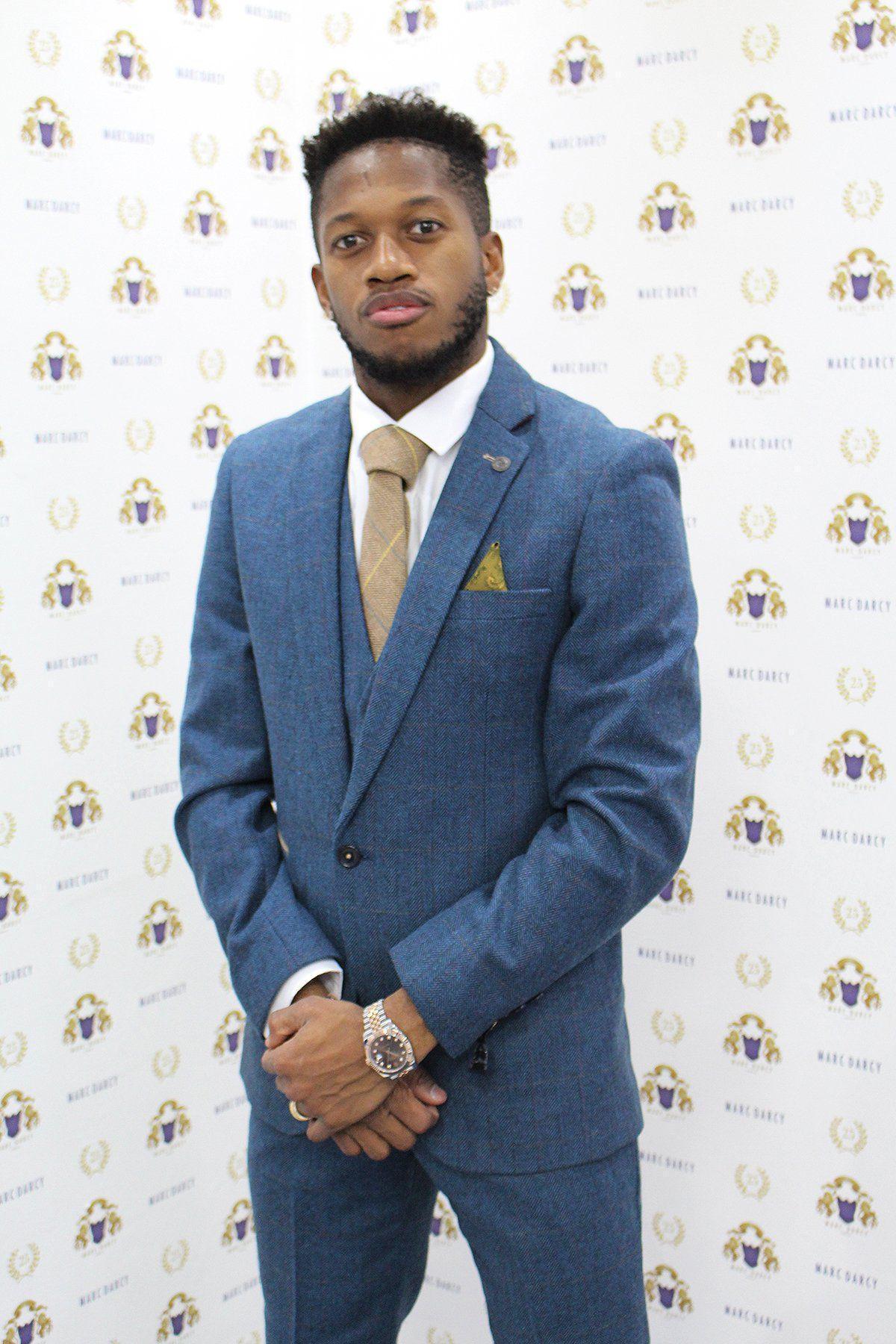 Fenerbahçe and Brazil midfielder Fred wears a marcdarcy Dion Blue Tweed Check Suit, beige tie, and gold pocket square, posing confidently before a white backdrop with the marcdarcy logo.