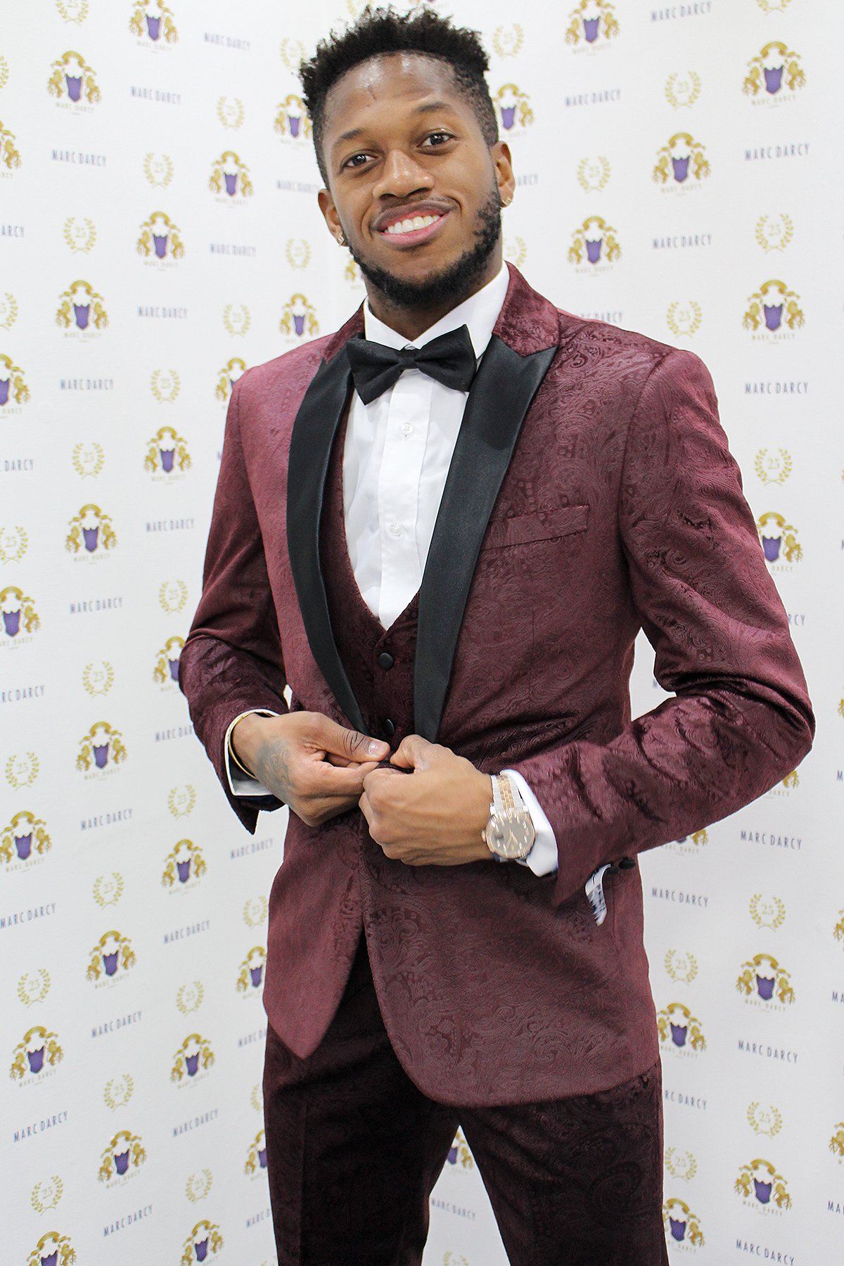 Fenerbahçe and Brazil midfielder Fred wears a slim fit Simon Wine Velvet suit by Marc Darcy, posing with a smile in front of a step-and-repeat banner featuring Marc Darcy logos.